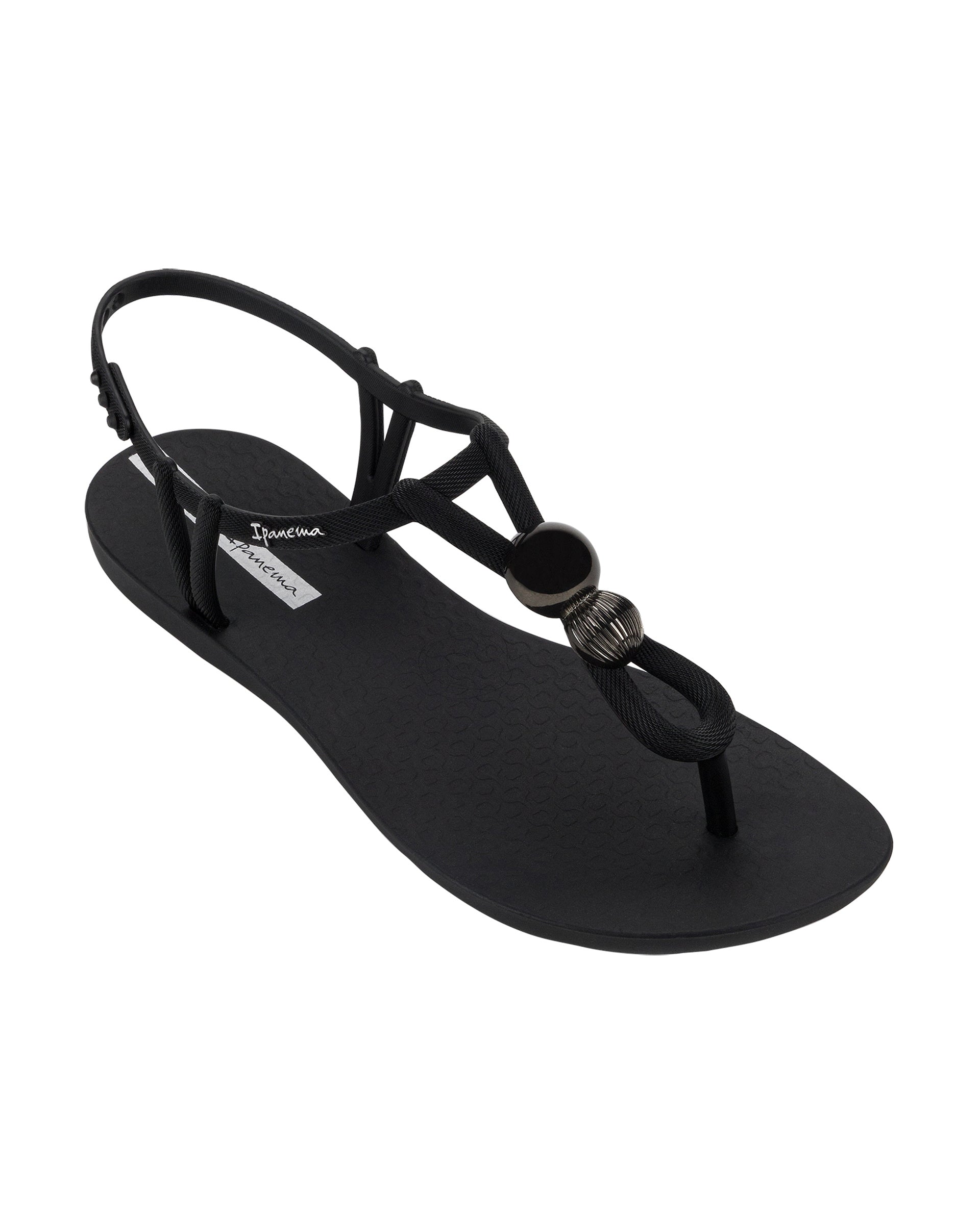 Angled view of a black Ipanema Class Spheres women's t-strap sandal with metallic bauble.