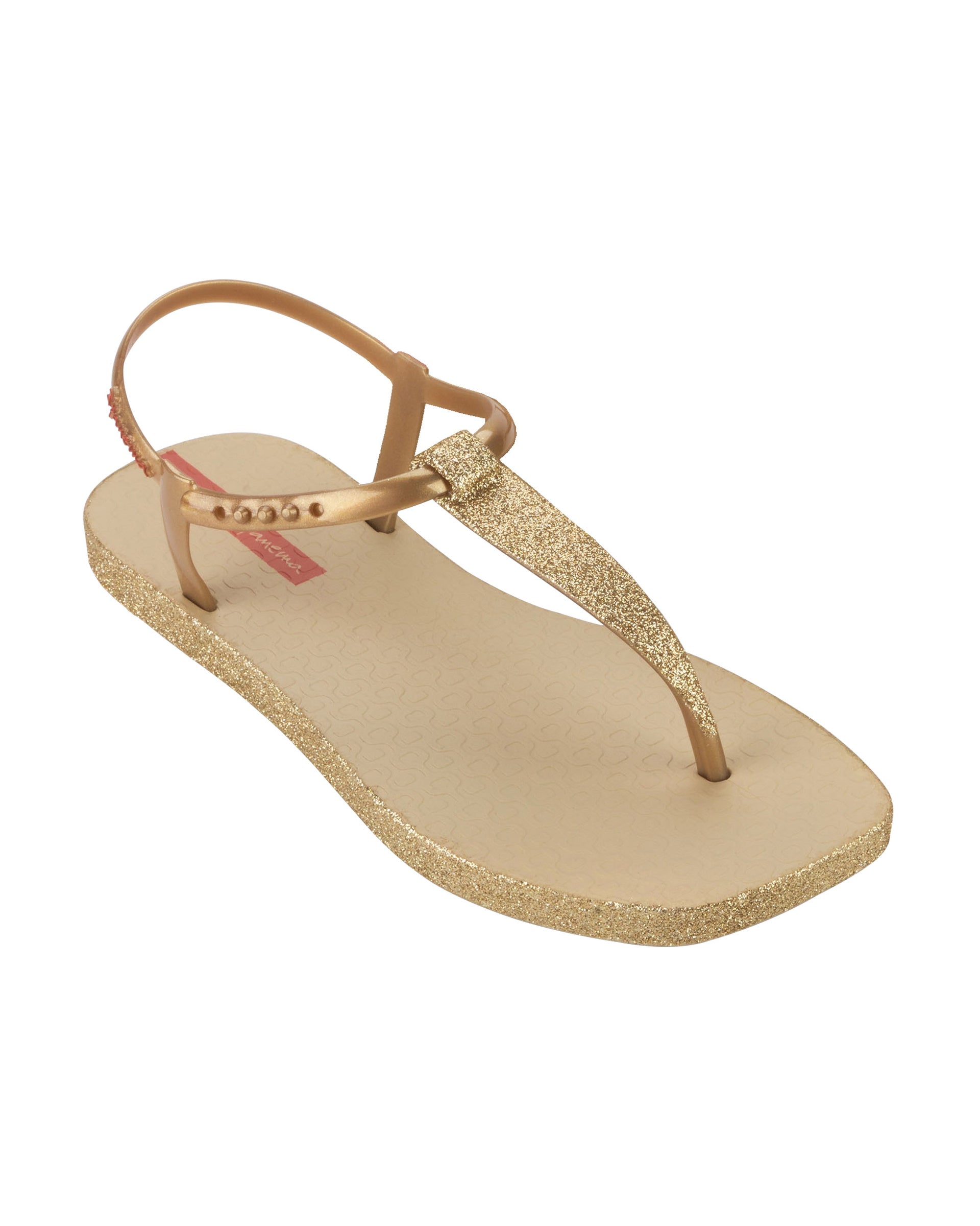 Angled view of a beige Ipanema Class Edge Glow t-strap women's sandal with gold strap and glitter thong.