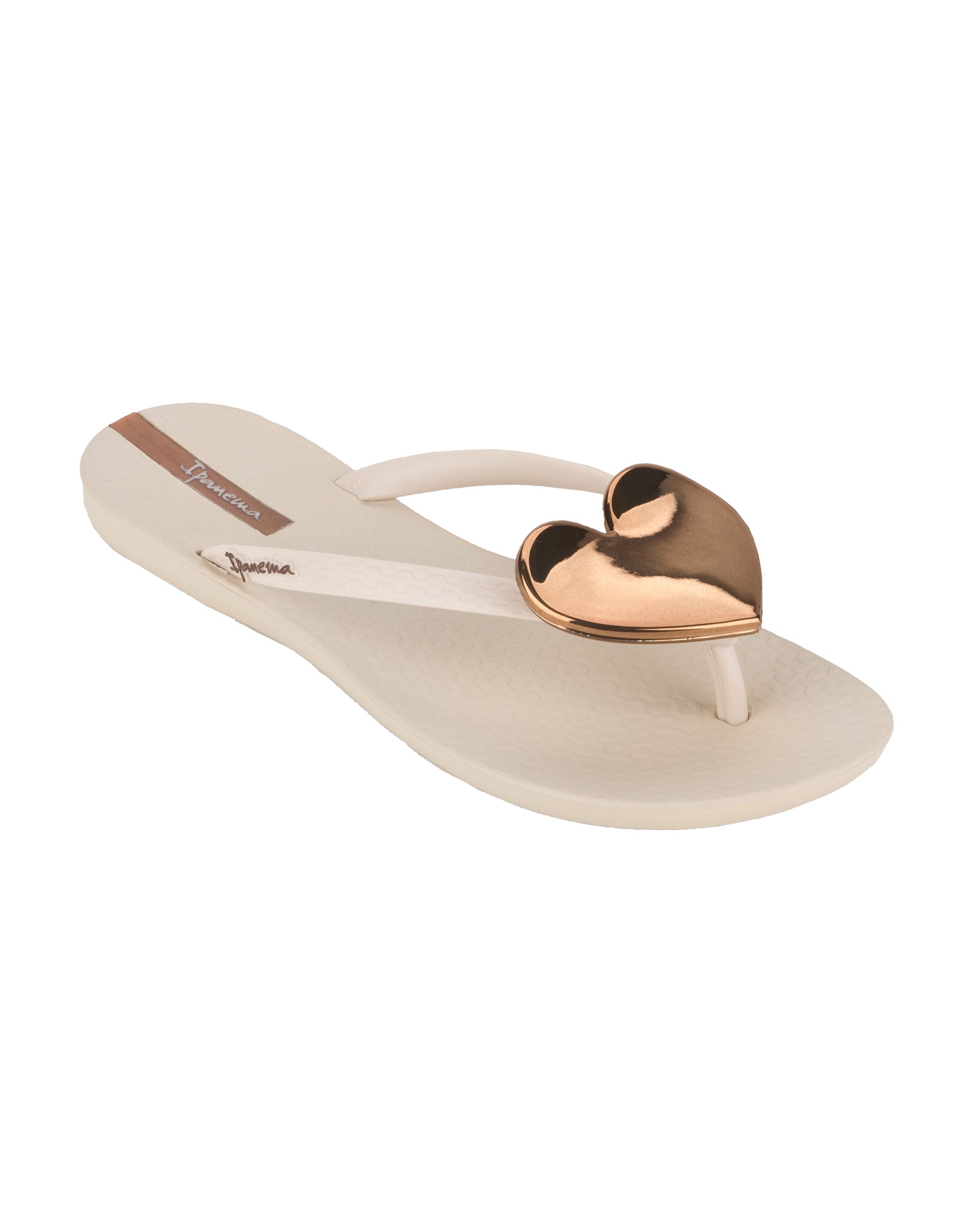 Angled view of a beige Ipanema Wave Heart women's flip flop with bronze heart.
