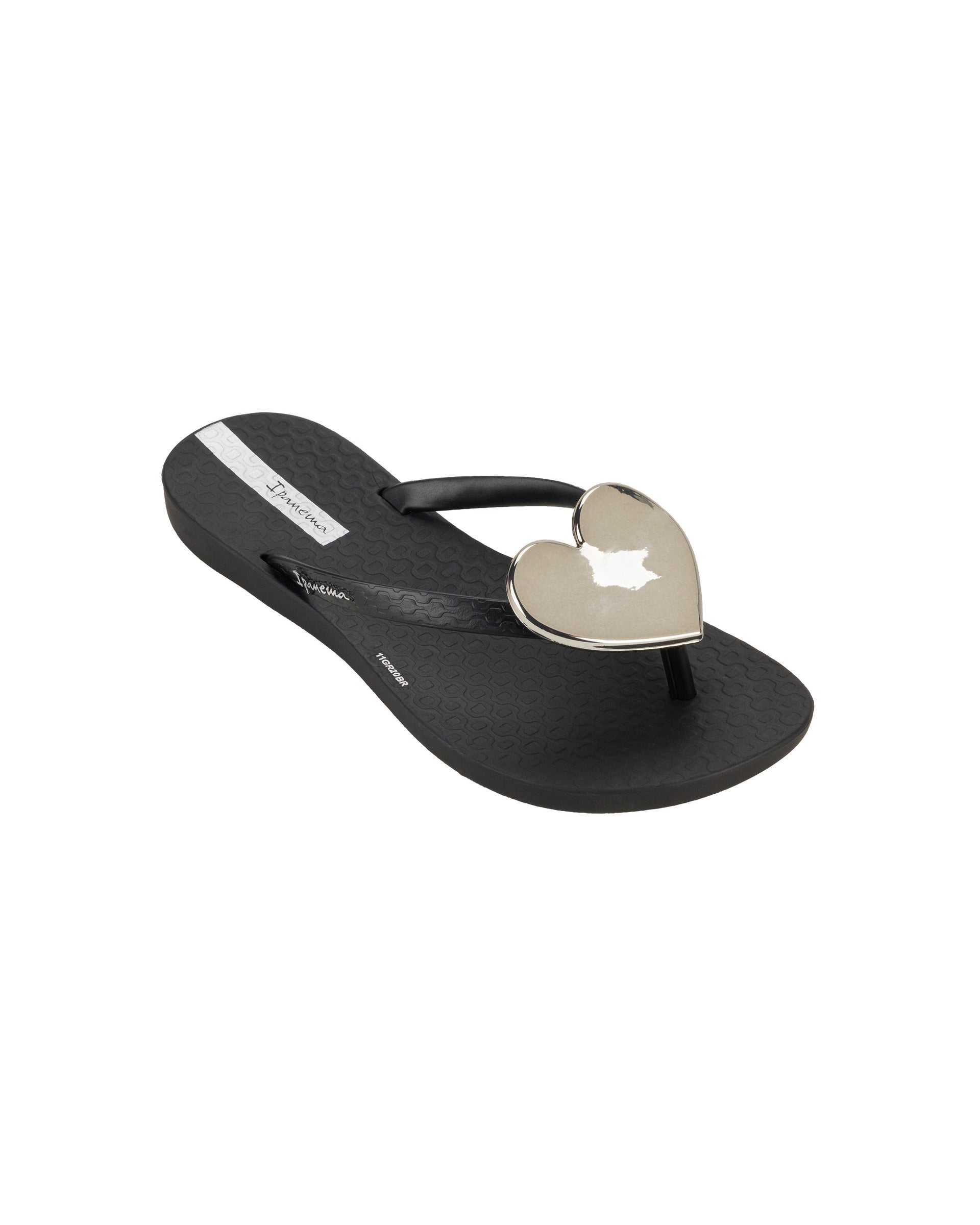 Angled view of a black Ipanema Wave Heart kids flip flop with gold decorative heart on the upper.