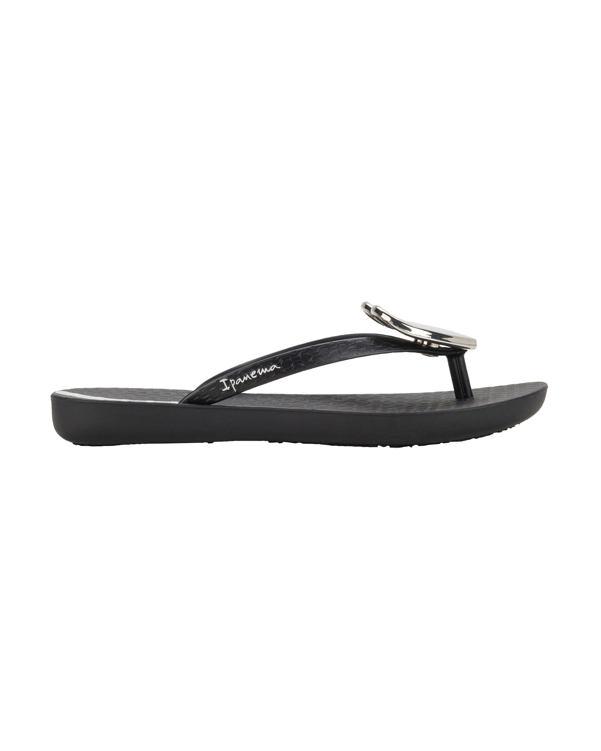 Outer side view of a black Ipanema Wave Heart kids flip flop with gold decorative heart on the upper.