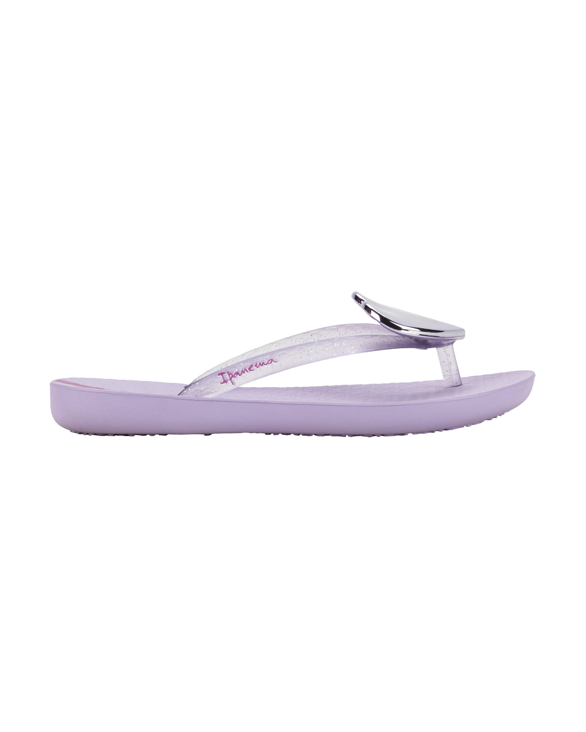 Outer side view of a purple Ipanema Wave Heart kids flip flop with silver decorative heart on the clear purple upper.