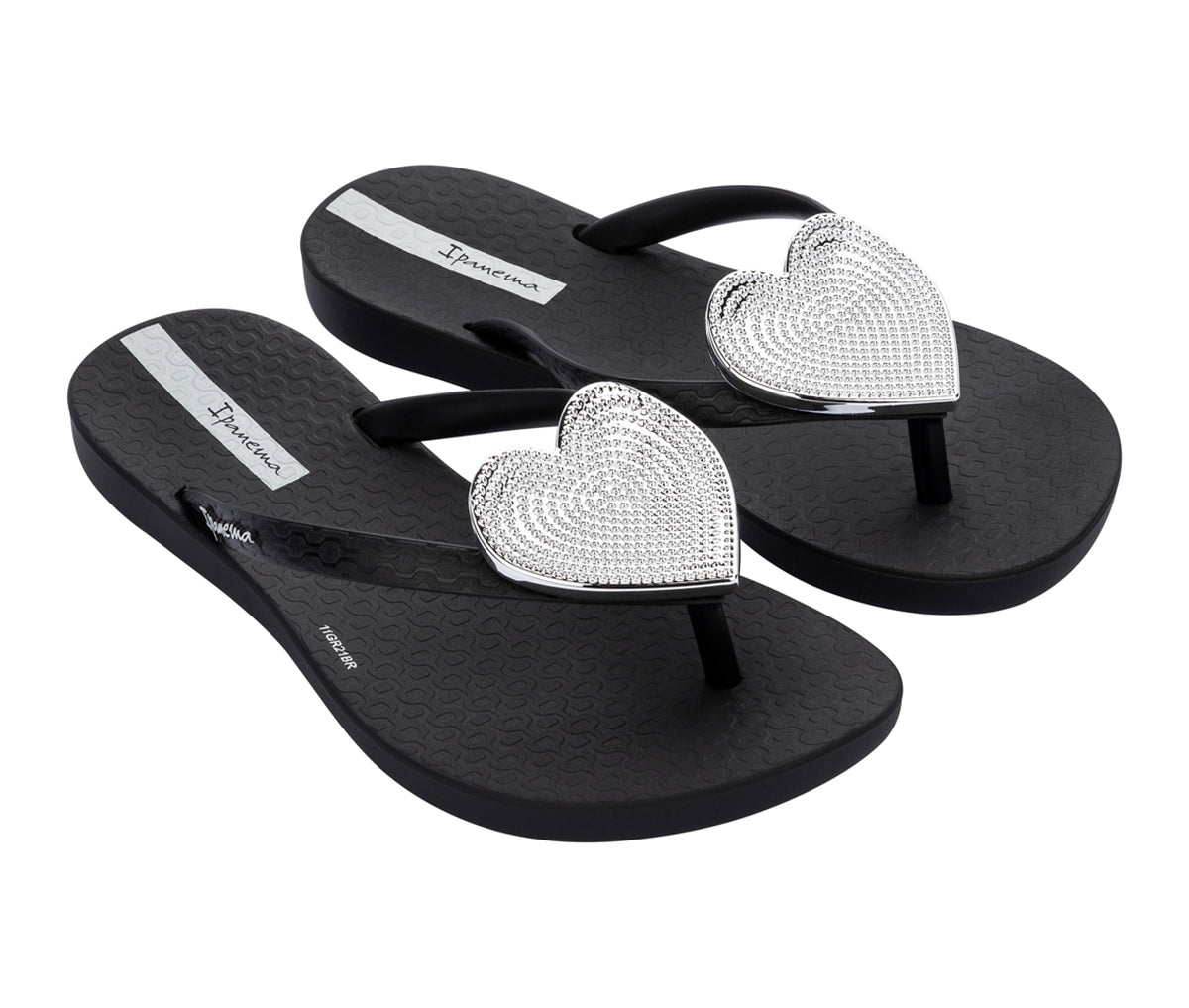 Angled view of a pair of black Ipanema Wave Heart kids flip flops with a metallic Silver heart on top.