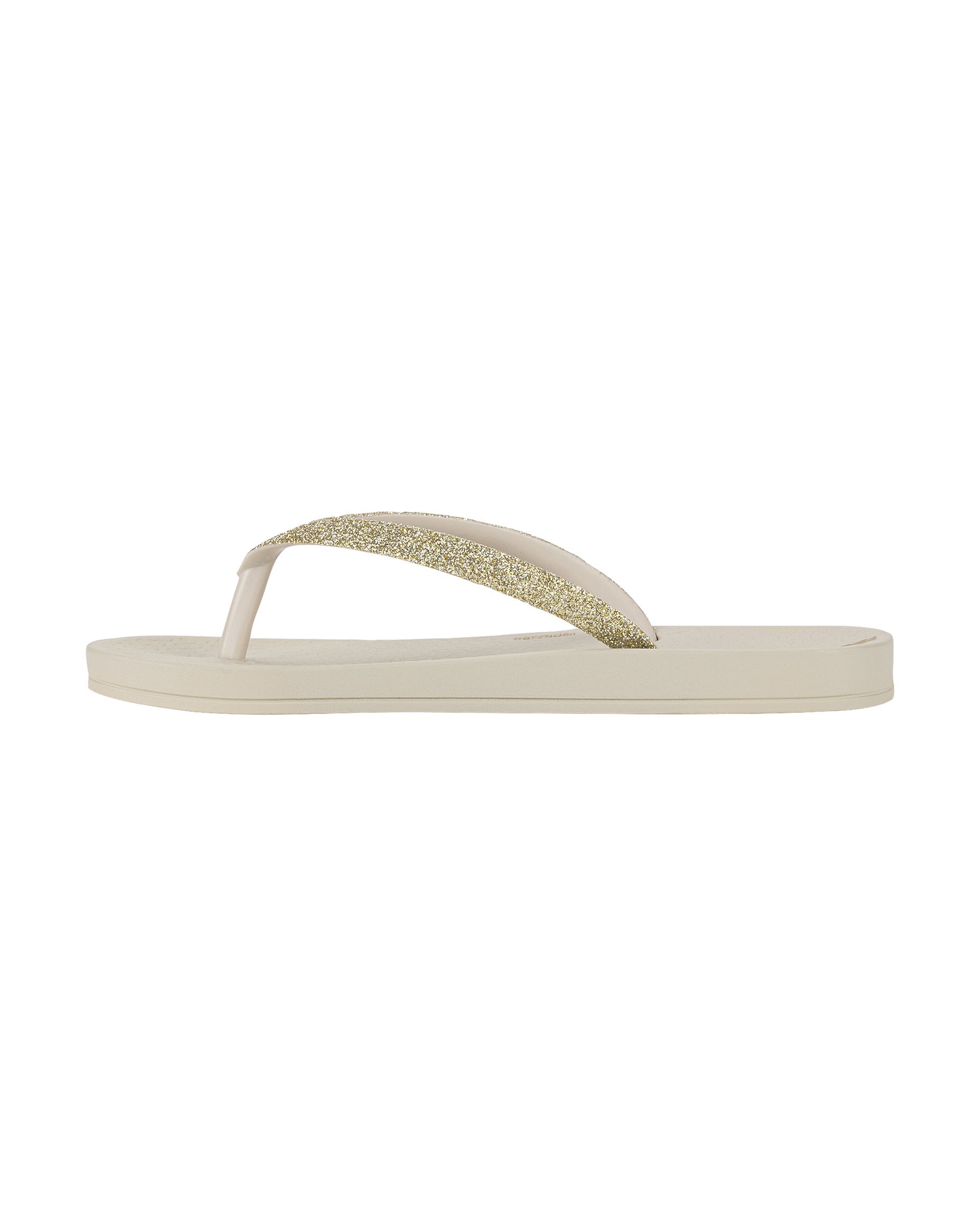 Inner side view of a beige Ipanema Ana Sparkle kids flip flop with gold glitter strap.