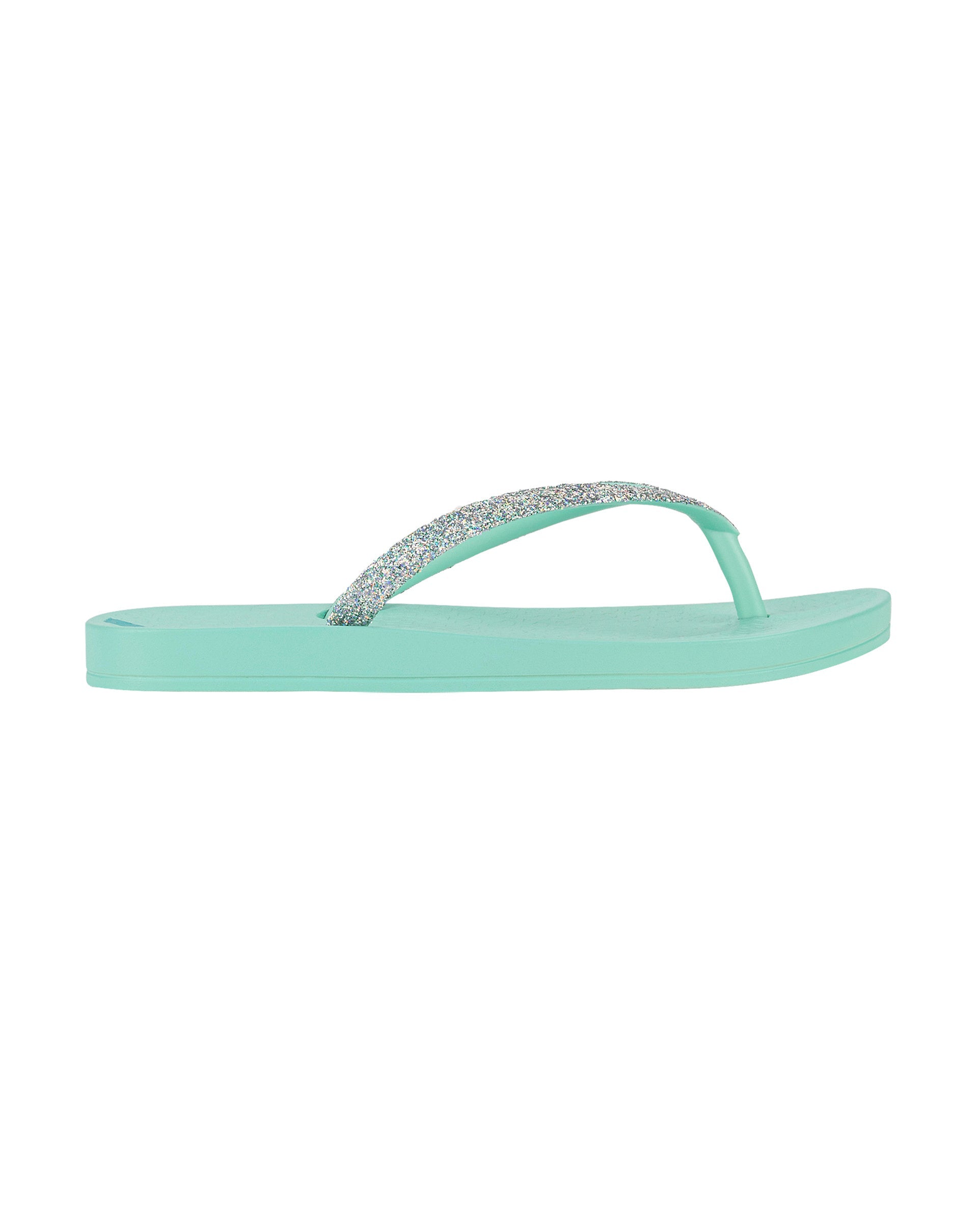 Outer side view of a green Ipanema Ana Sparkle kids flip flop with silver glitter strap.