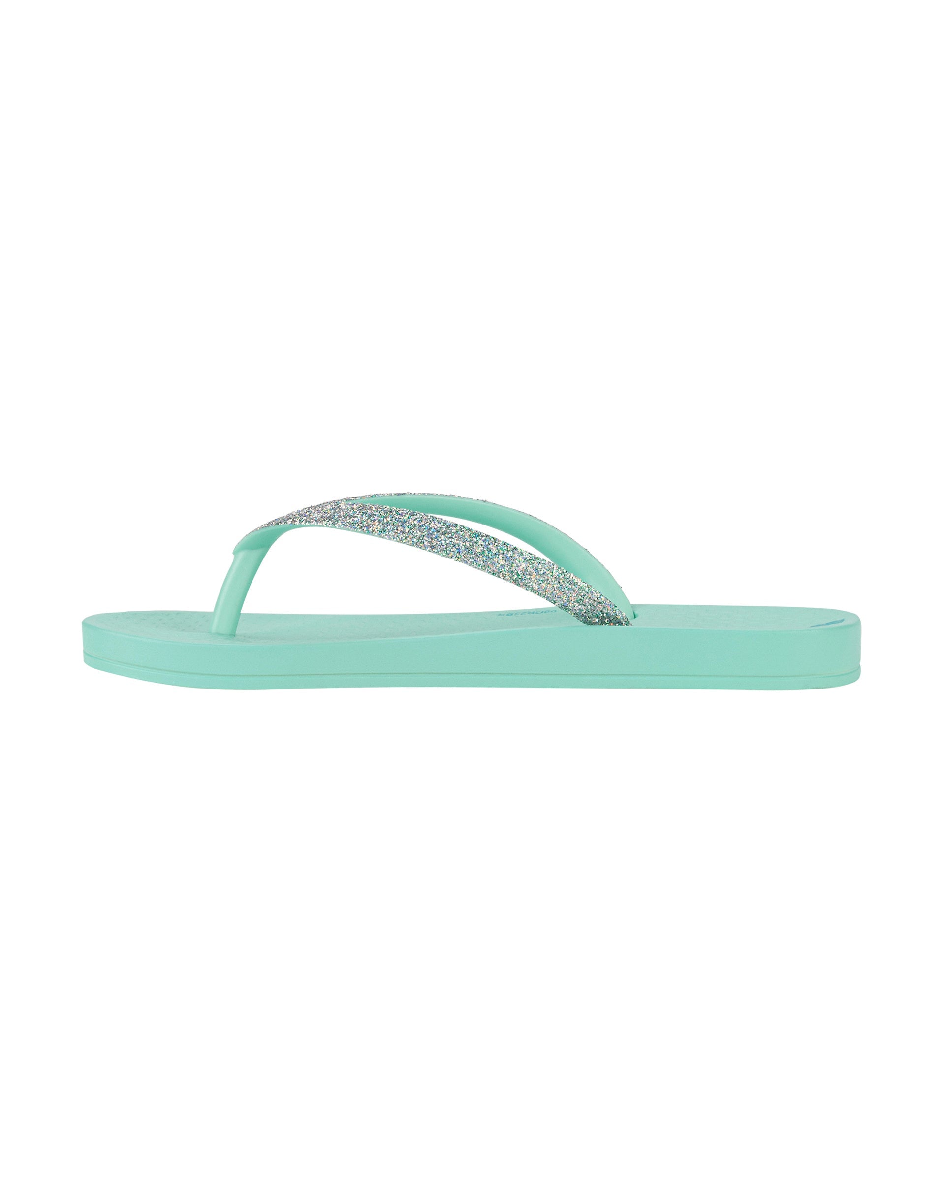 Inner side view of a green Ipanema Ana Sparkle kids flip flop with silver glitter strap.