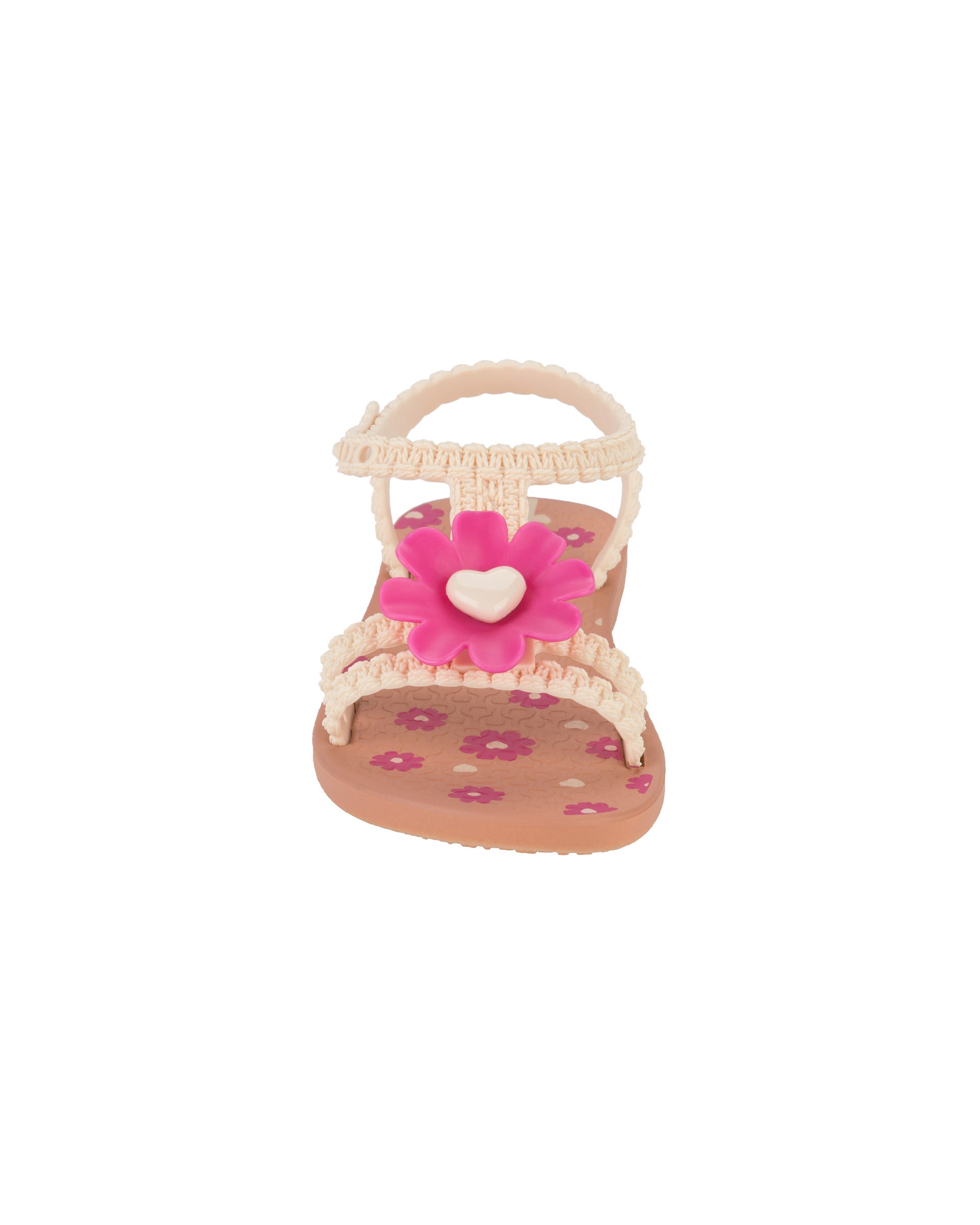 Front view of a pink Ipanema Daisy baby sandal with pink flower on top and crochet texture .