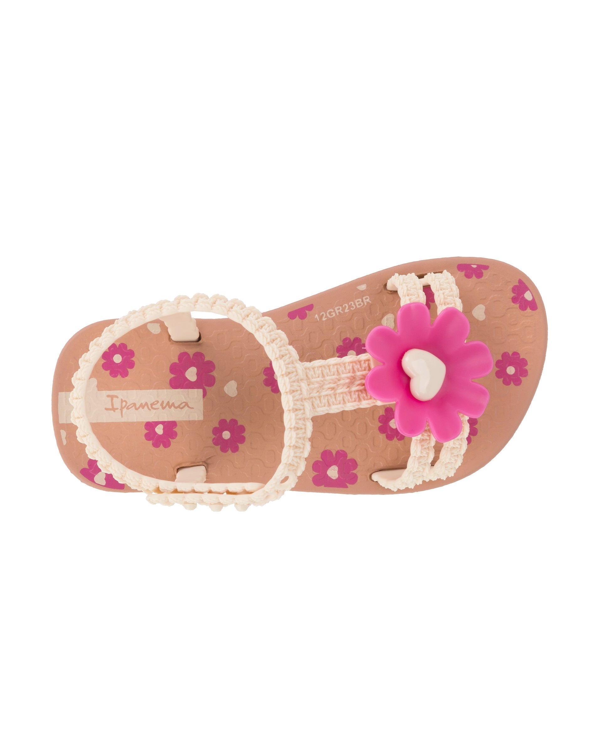 Top view of a pink Ipanema Daisy baby sandal with pink flower on top and crochet texture .