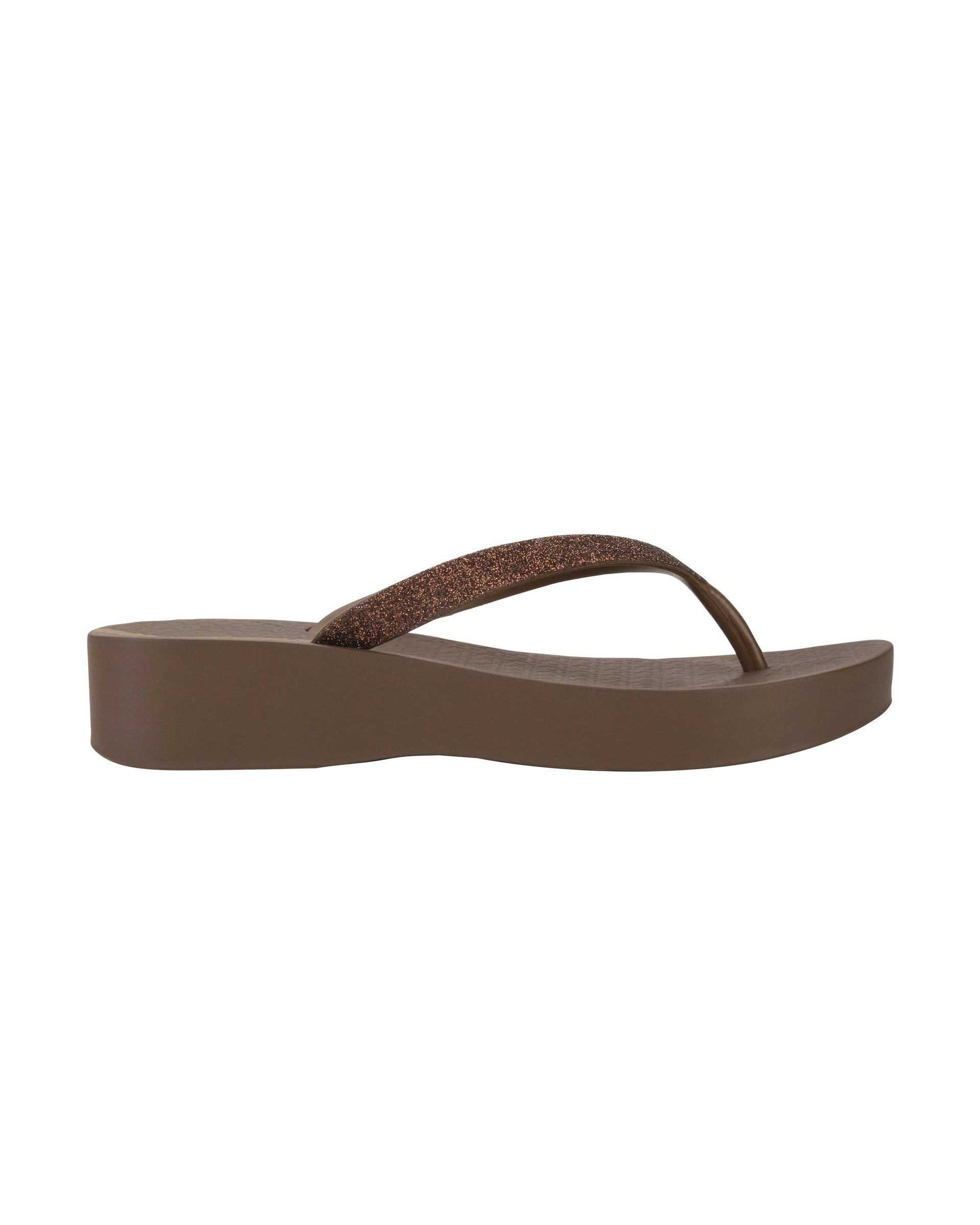 Outer side view of a brown Ipanema Mesh Chic women's wedge flip flop with glitter brown straps.