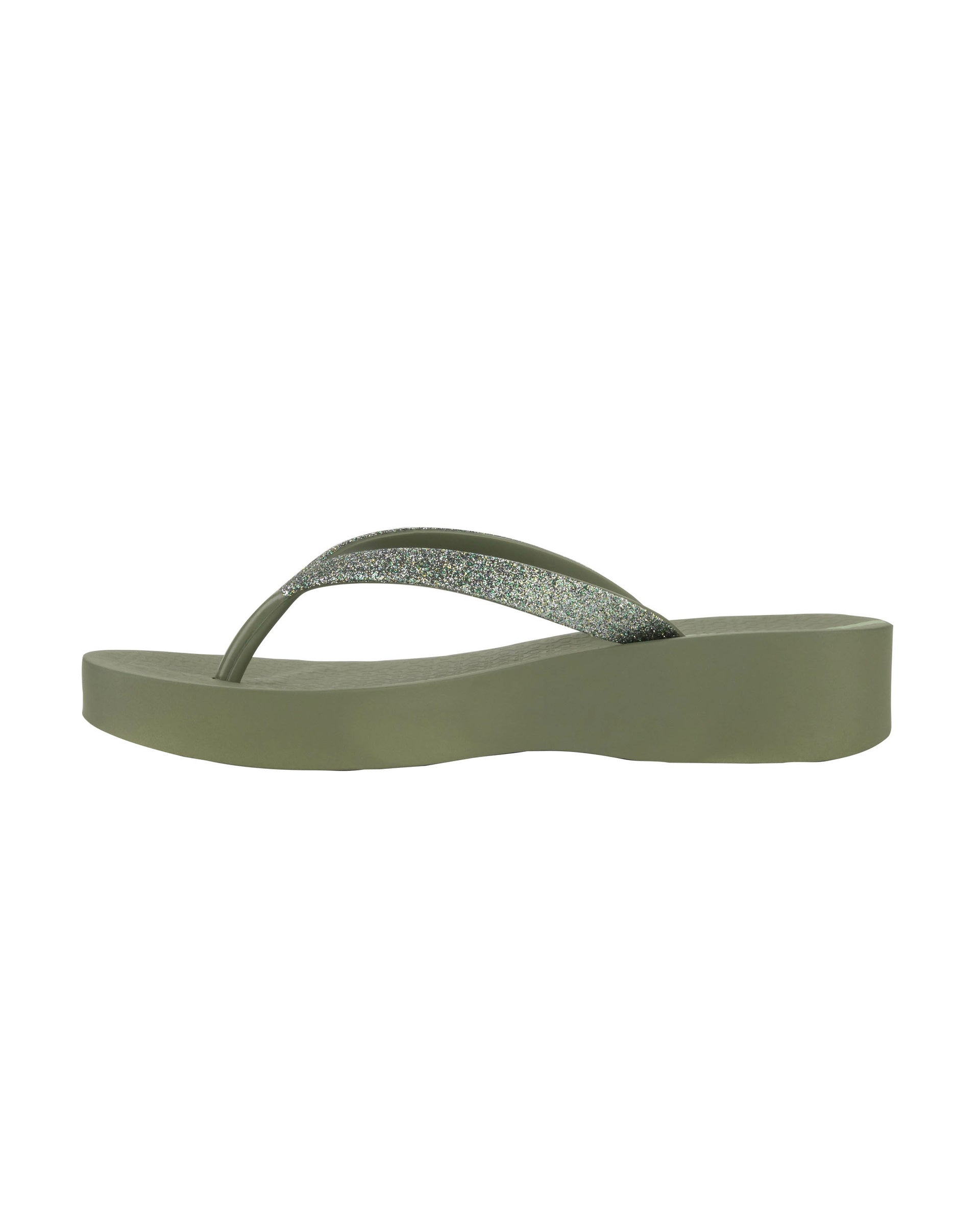 Inner side view of a green Ipanema Mesh Chic women's wedge flip flop with glitter green straps.