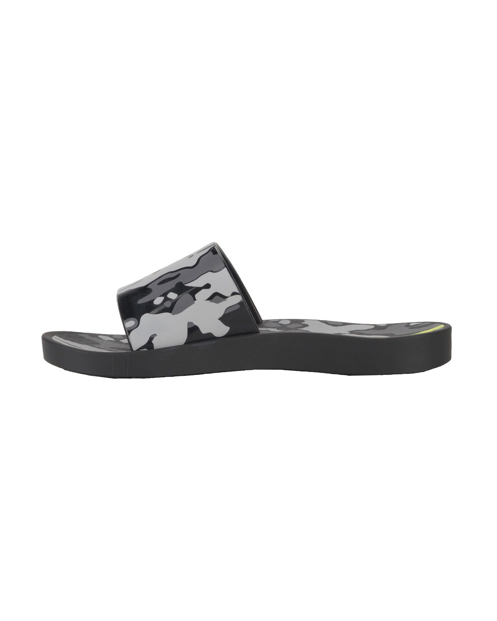 Inner side view of a black Ipanema Urban kids slide with a camo print on the upper.
