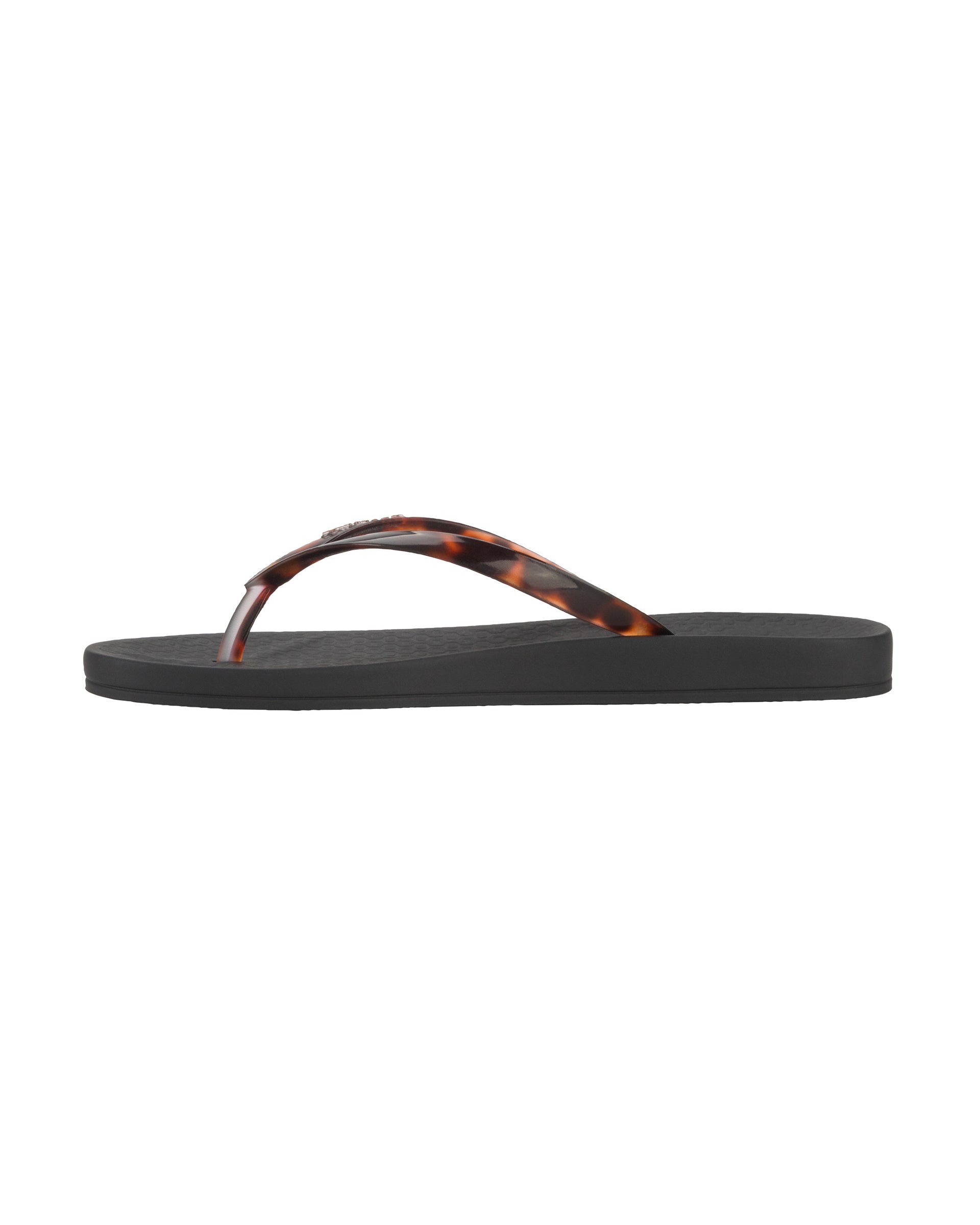 Inner side view of a black Ipanema Ana Connect women's flip flop with brown tortoiseshell  color strap.