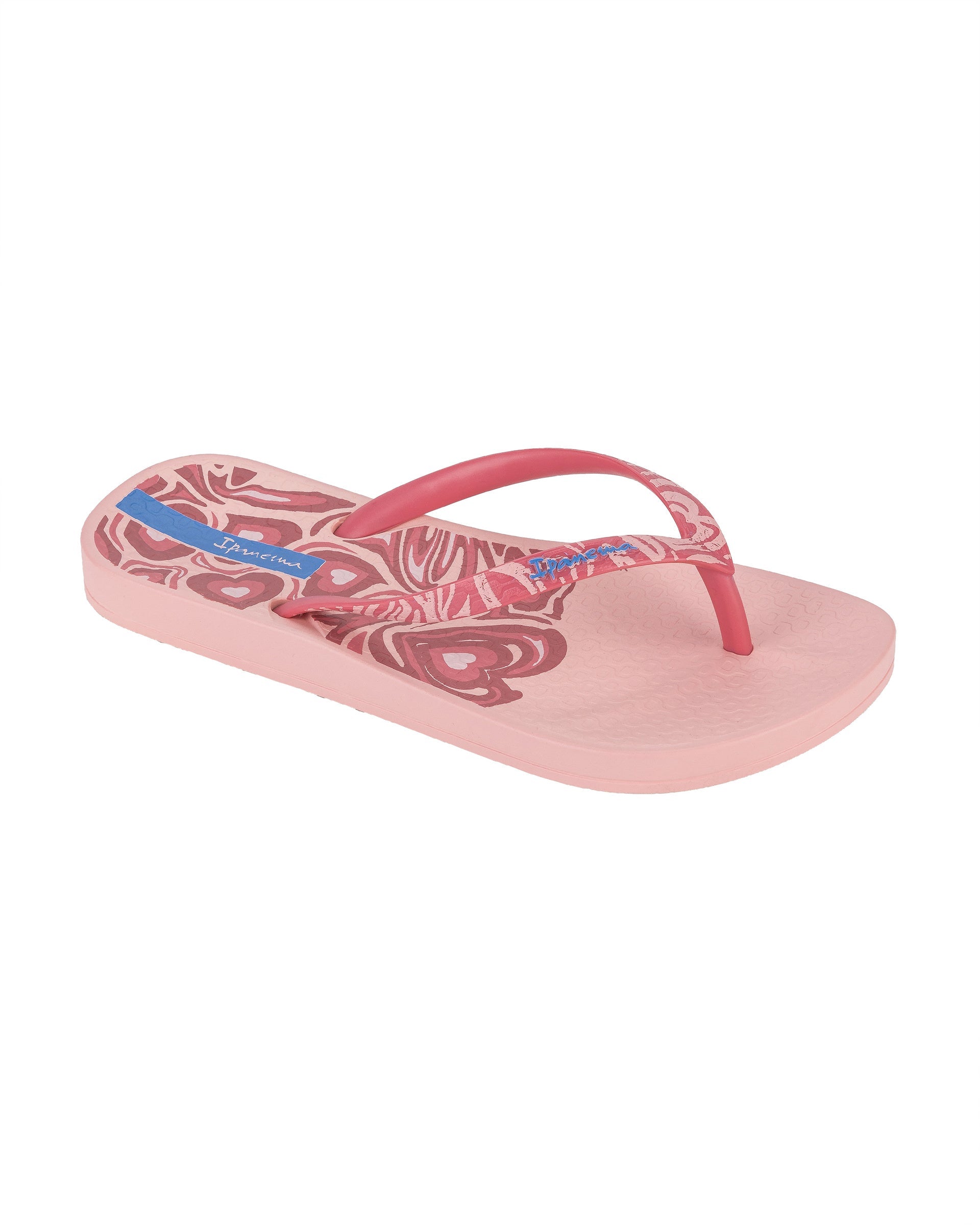 Angled view of a light pink Ipanema Nostalgic Hearts kid's flip flop with heart outlines on insole and strap.