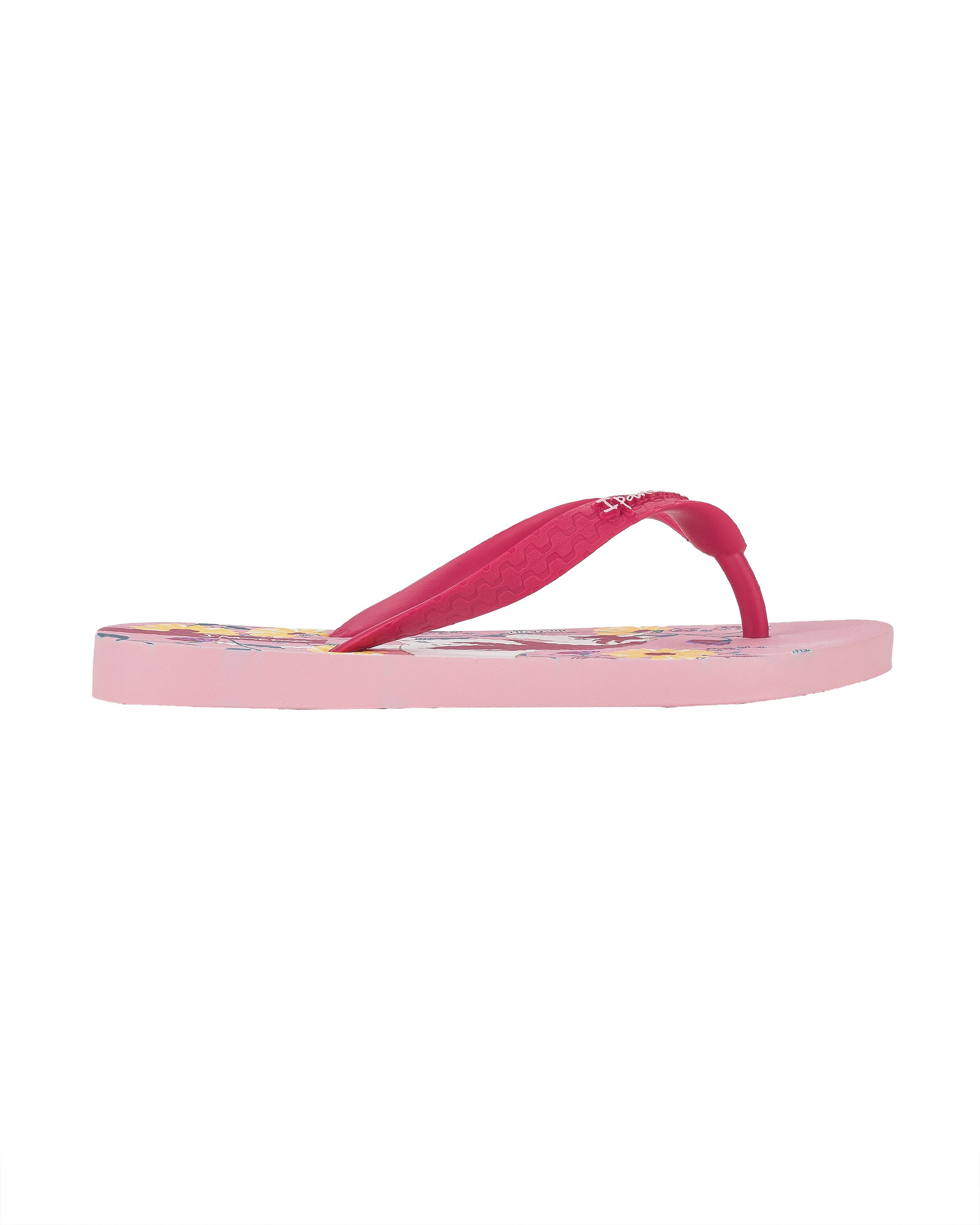 Outer side view of a pink Ipanema Temas kids flip flop with unicorn and flower print.