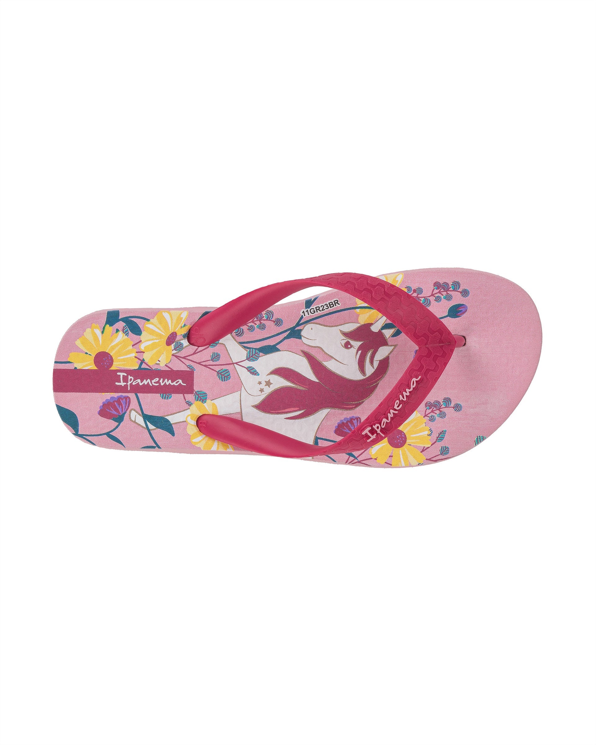 Top view of a pink Ipanema Temas kids flip flop with unicorn and flower print.