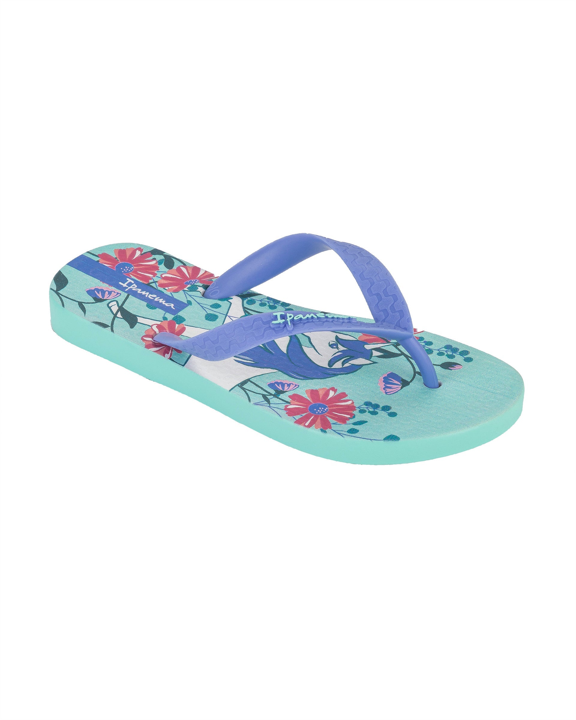 Angled view of a blue Ipanema Temas kids flip flop with unicorn and flower print.