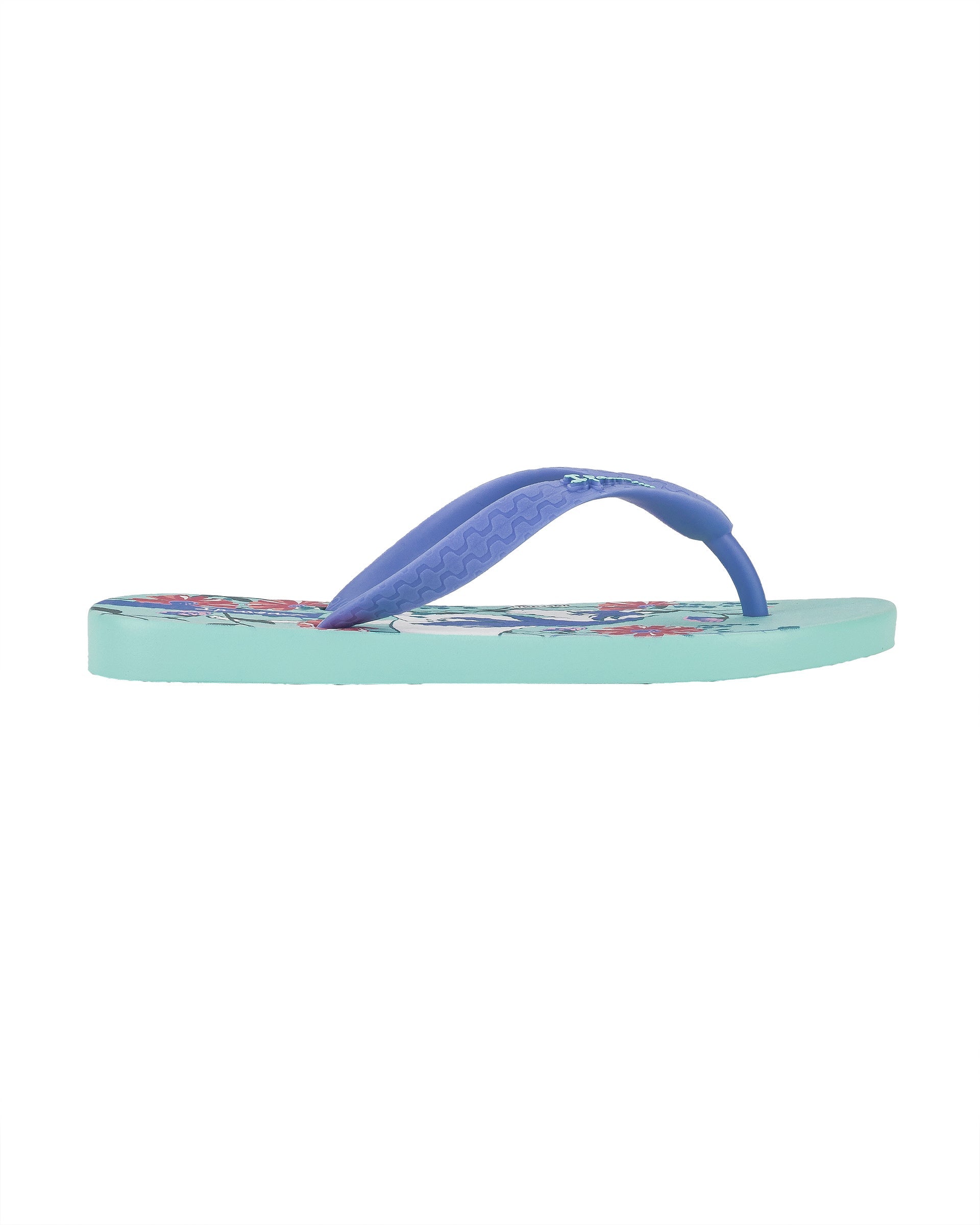 Outer side view of a blue Ipanema Temas kids flip flop with unicorn and flower print.