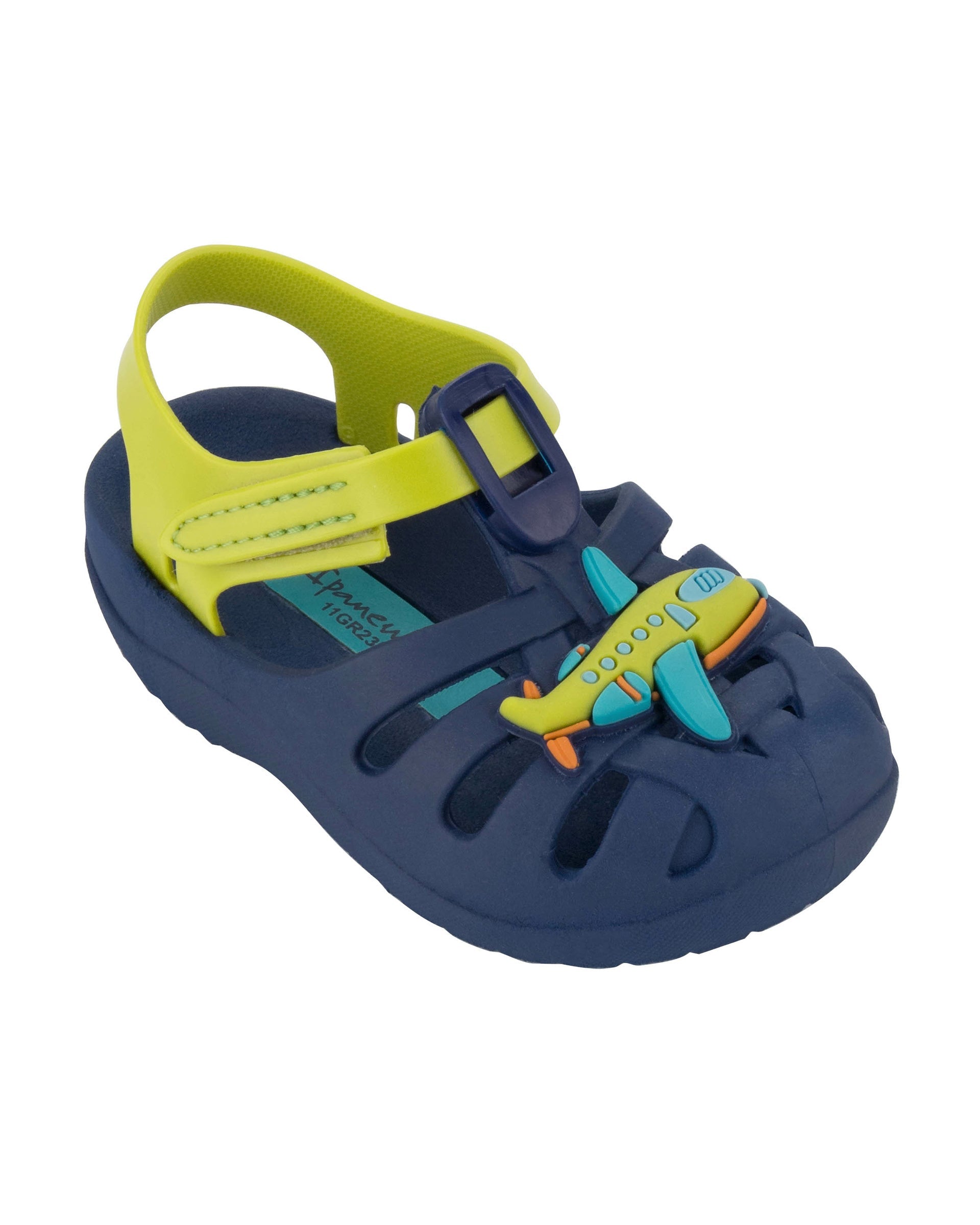 Angled view of a blue Ipanema Summer baby sandal with airplane on the upper and a green strap.