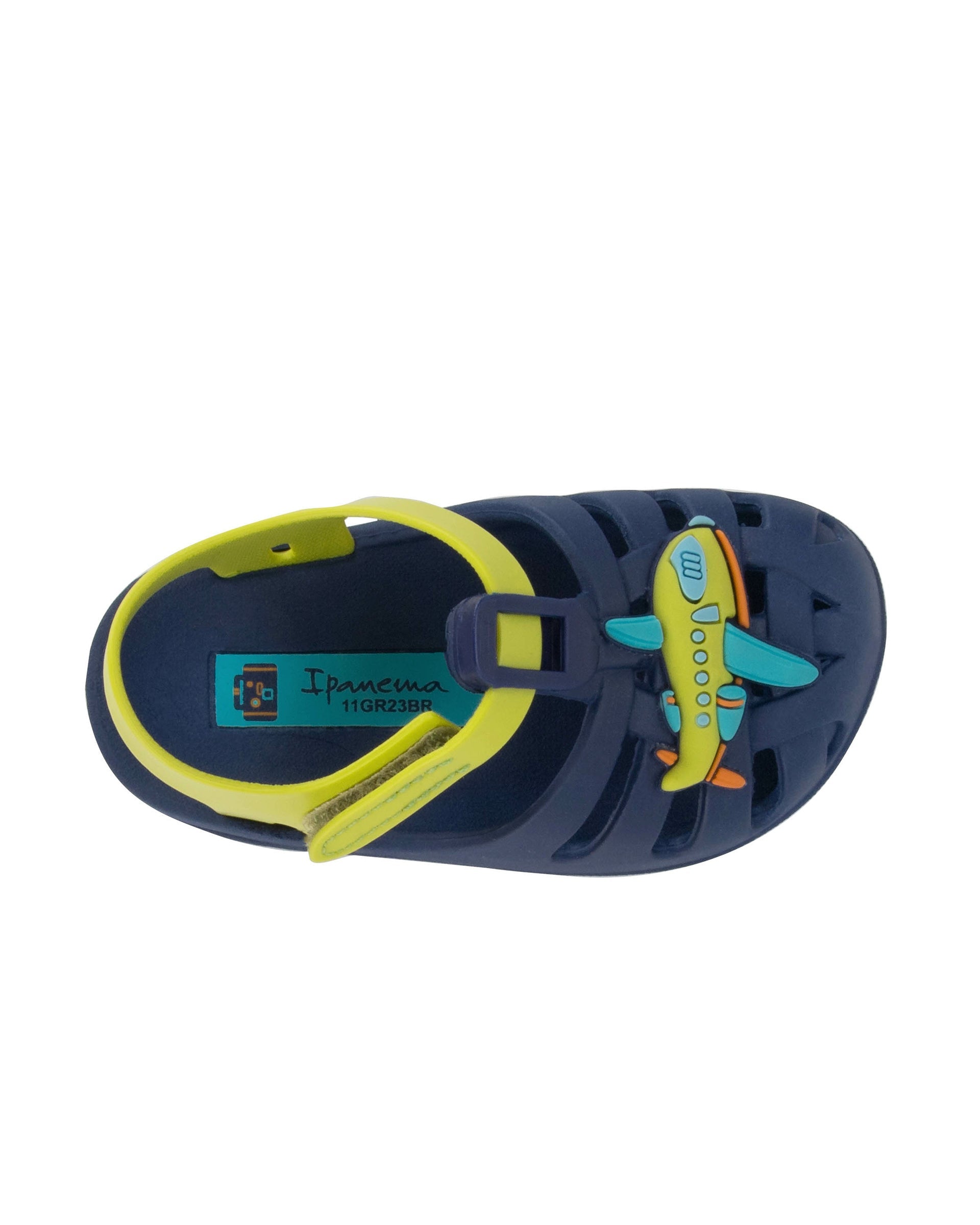 Top view of a blue Ipanema Summer baby sandal with airplane on the upper and a green strap.