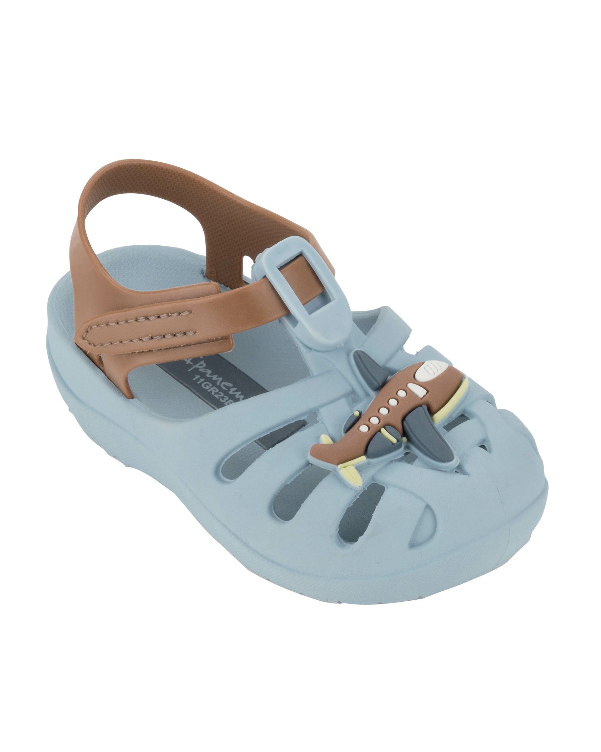 Angled view of a blue Ipanema Summer baby sandal with airplane on the upper and a brown strap.