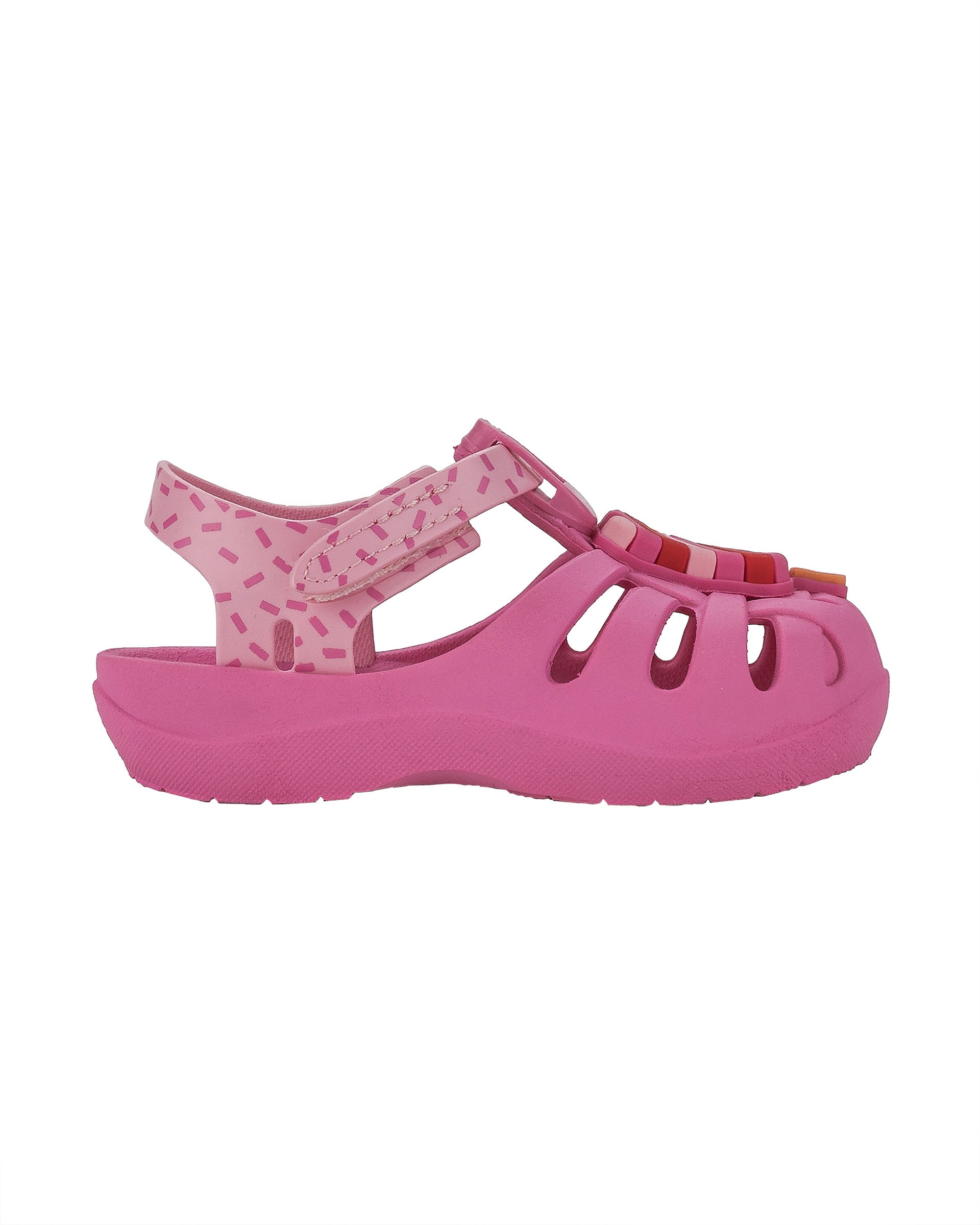 Outer side view of a pink Ipanema Summer baby fisherman sandal with a popsicle on the upper.