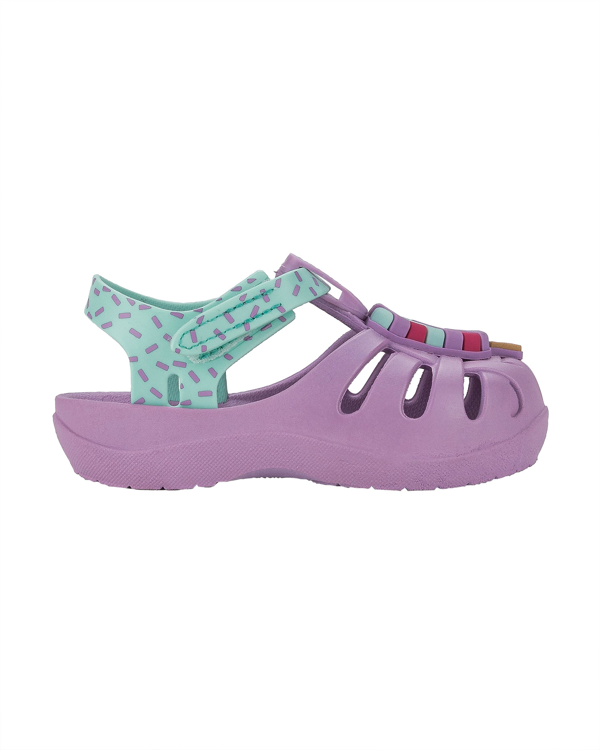 Outer side view of a purple and green Ipanema Summer baby fisherman sandal with popsicle on the upper.