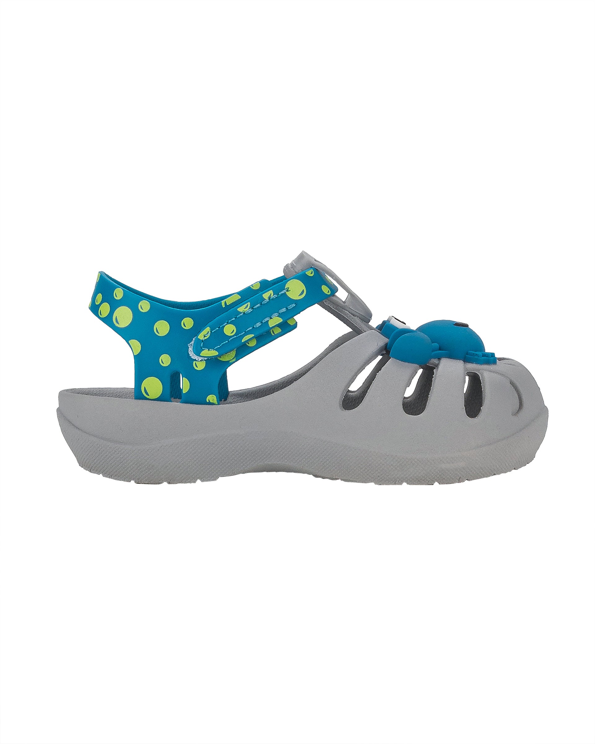 Outer side view of a grey and blue Ipanema Summer baby fisherman sandal with blue crab on upper and green bubbles on a blue strap.