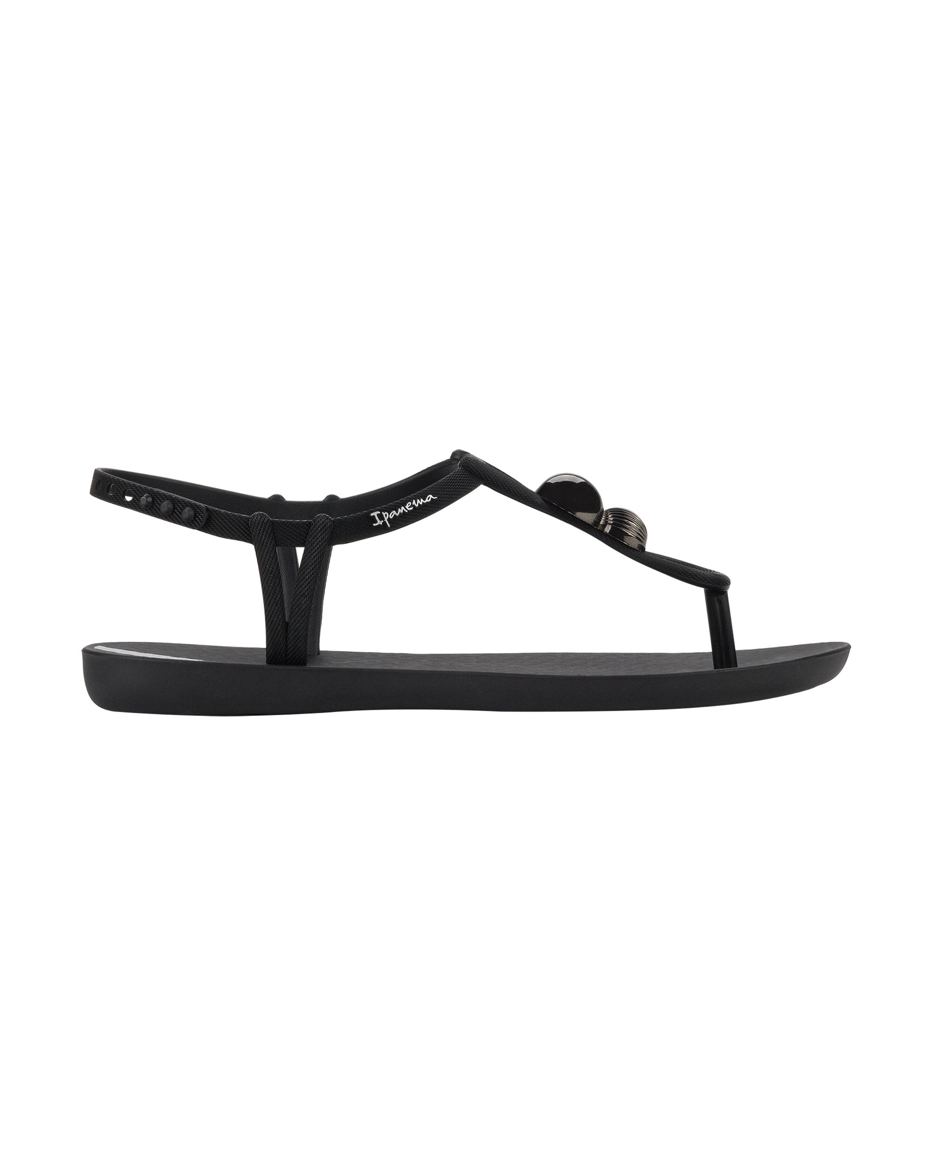 Outer side view of a black Ipanema Class Spheres women's t-strap sandal with metallic bauble.