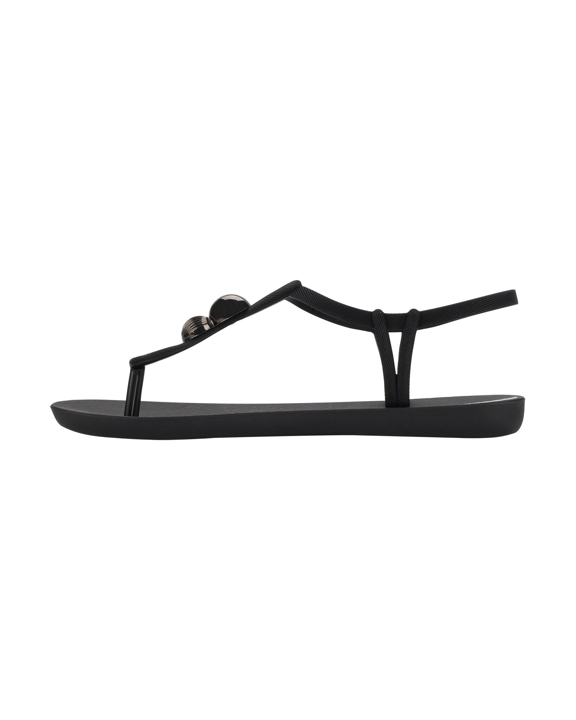 Inner side view of a black Ipanema Class Spheres women's t-strap sandal with metallic bauble.