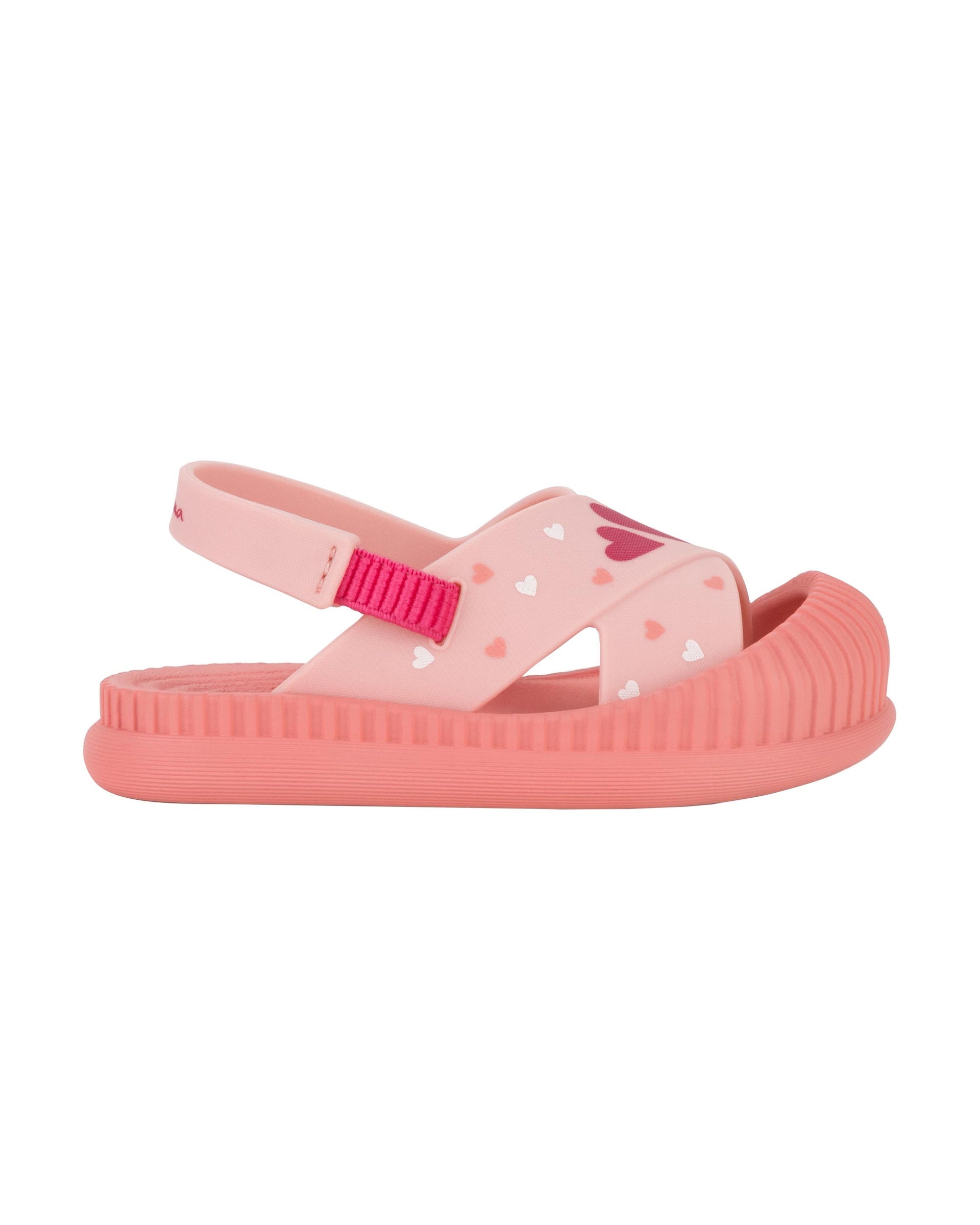 Outer side view of a pink Ipanema Cute baby sandal with hearts on the strap.