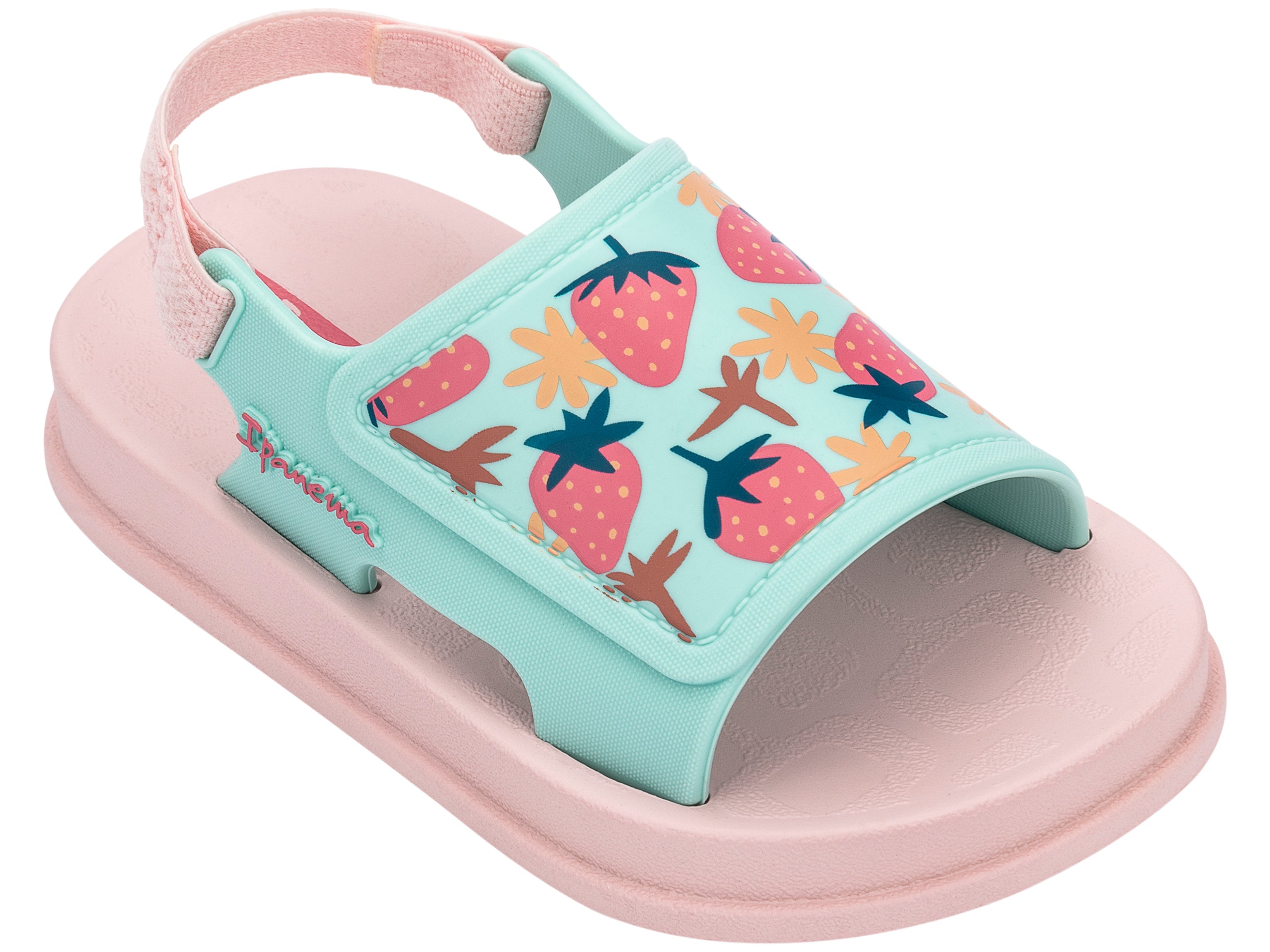 Angled view of a pink Ipanema Soft baby sandal with fruit print on the green upper.