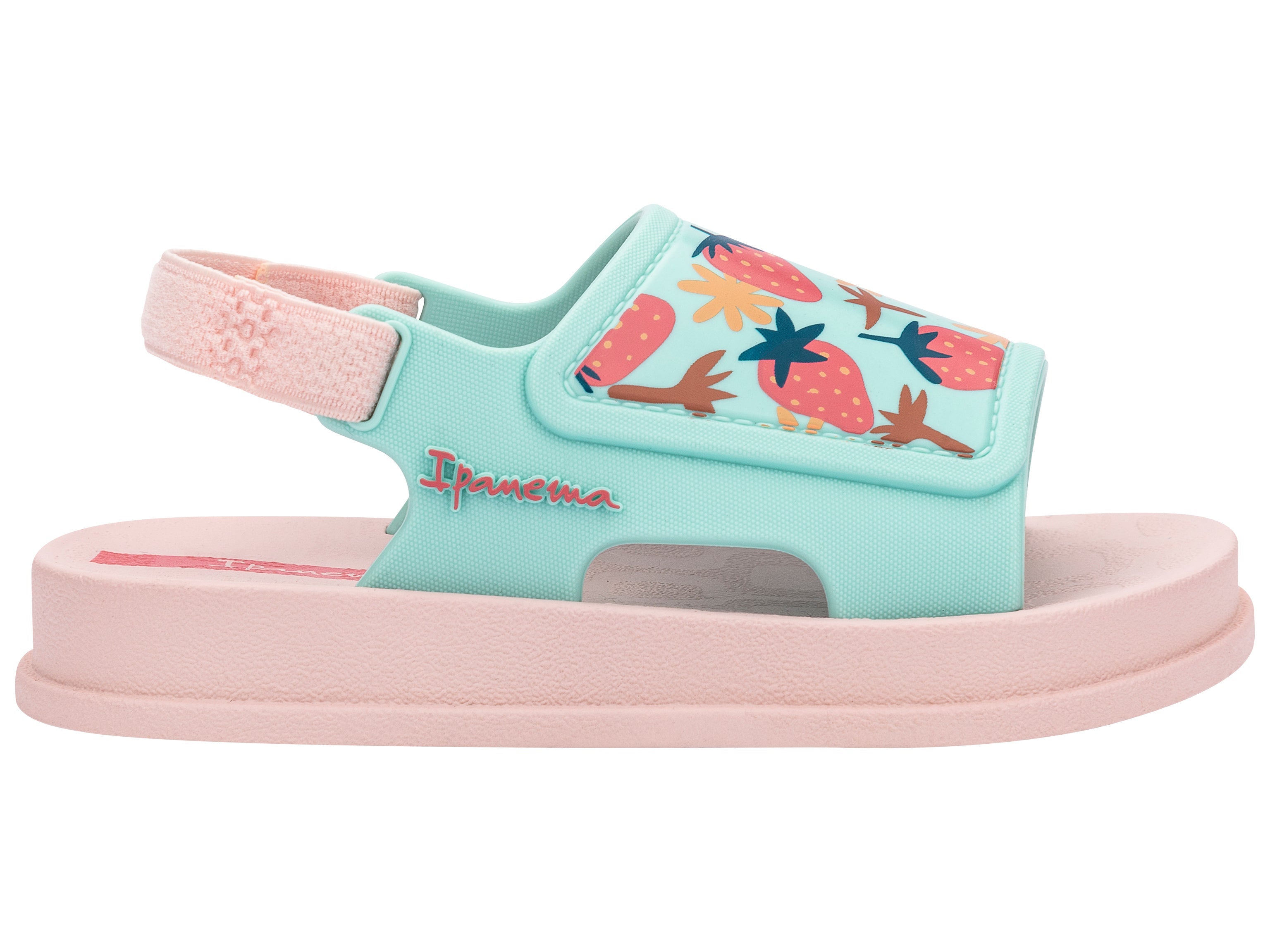 Outer side view of a pink Ipanema Soft baby sandal with fruit print on the green upper.