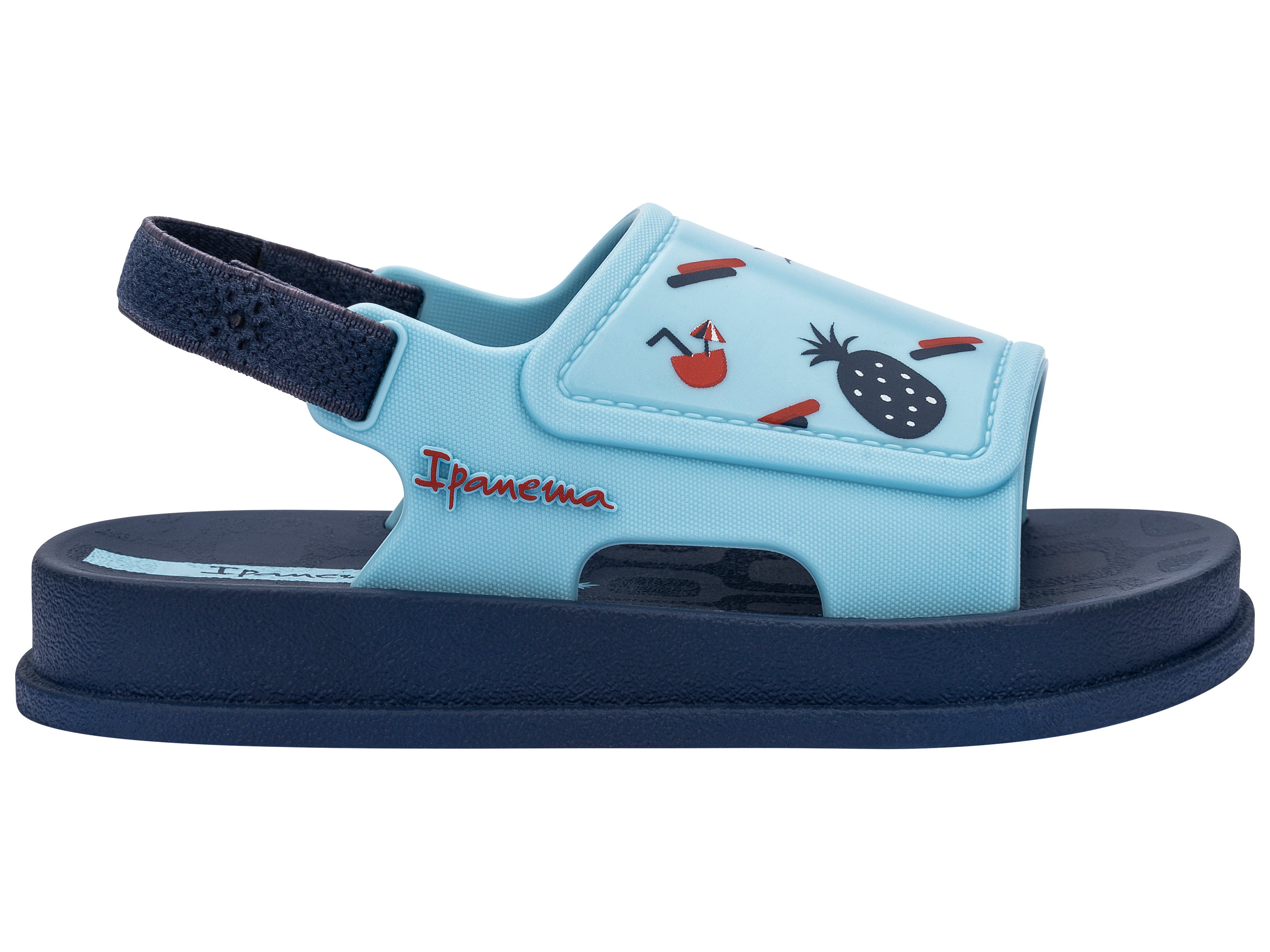 Outer side view of a blue Ipanema Soft baby sandal with fruit print on the upper.