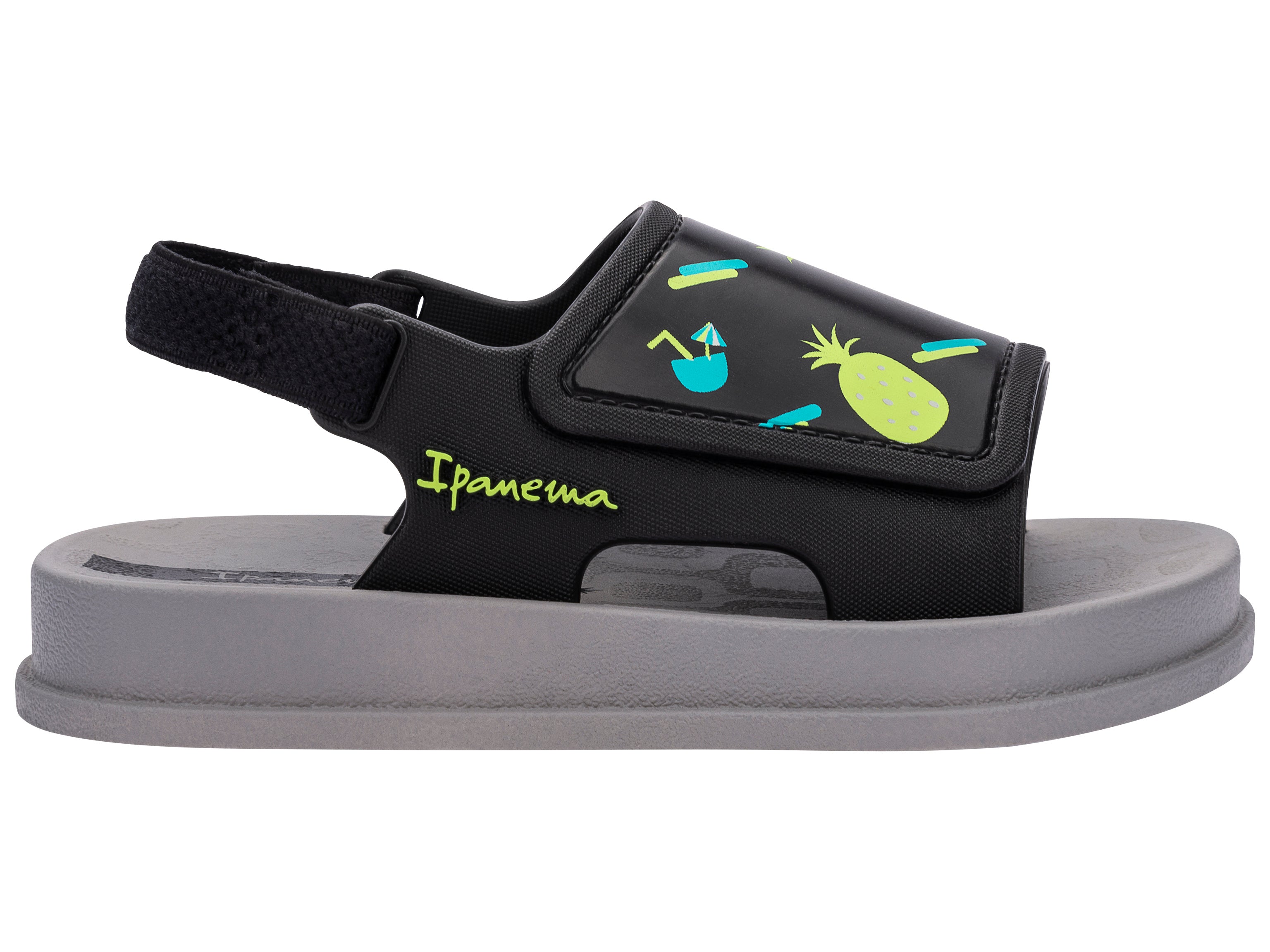 Outer side view of a grey Ipanema Soft baby sandal with fruit print on the black upper.