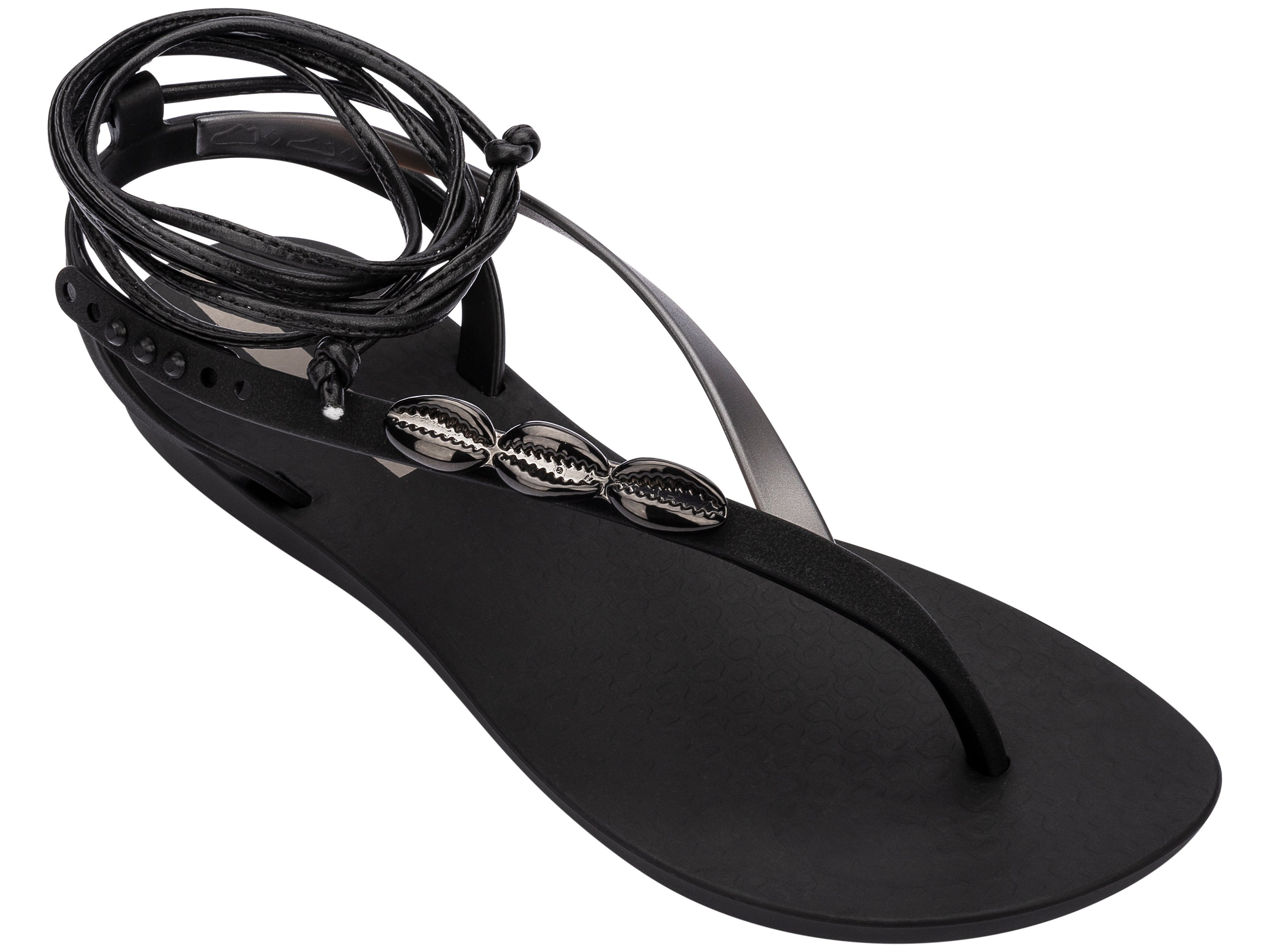 Angled view of a black Ipanema Salty Strappy women's sandal with ankle tie up and 3 silver shells on the strap.