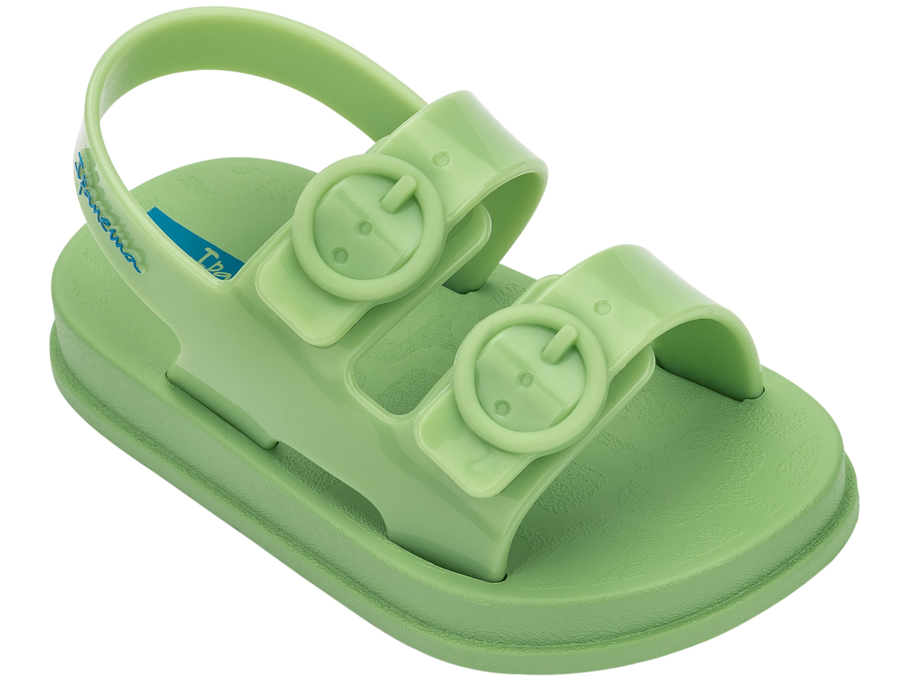Angled view of a green Ipanema Follow baby sandal with two decorative buckles on the upper.