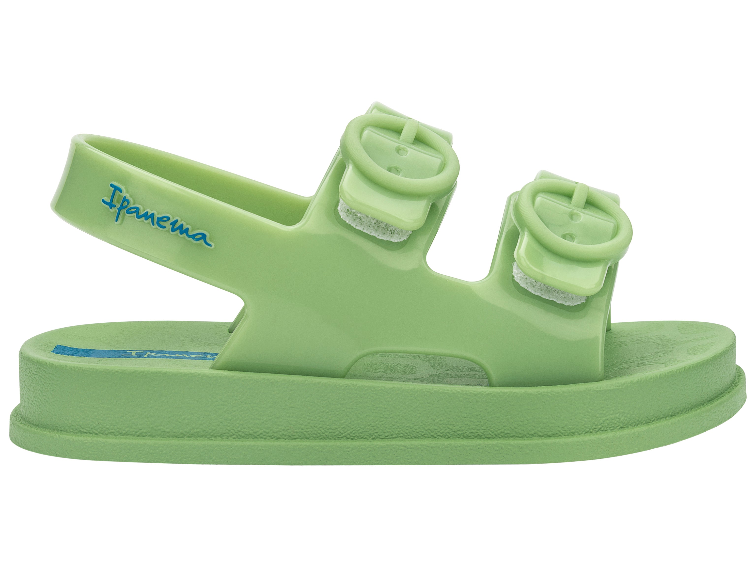 Outer side view of a green Ipanema Follow baby sandal with two decorative buckles on the upper.