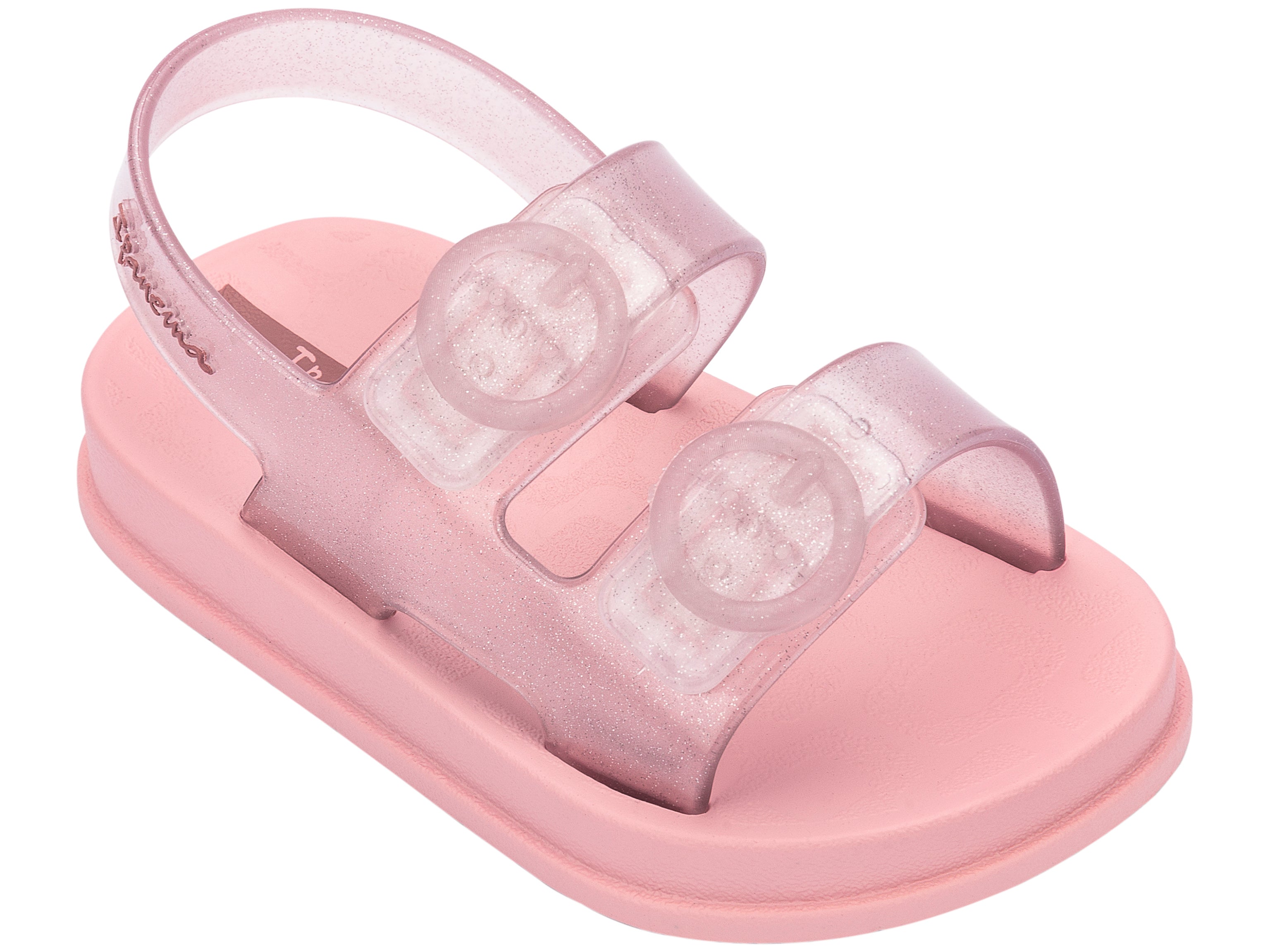 Angled view of a light pink Ipanema Follow baby sandal with two decorative buckles on the upper.