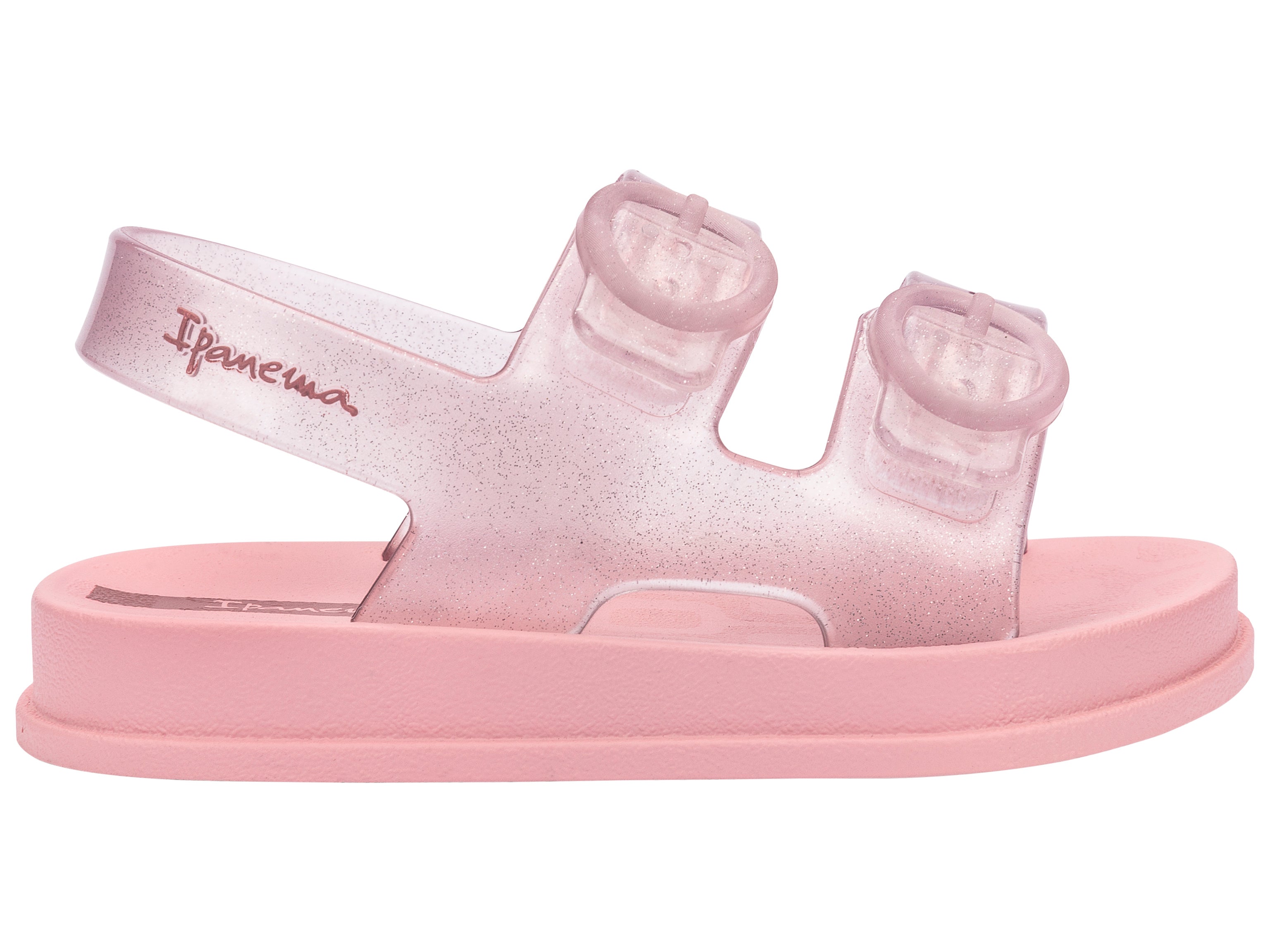 Outer side view of a light pink Ipanema Follow baby sandal with two decorative buckles on the upper.